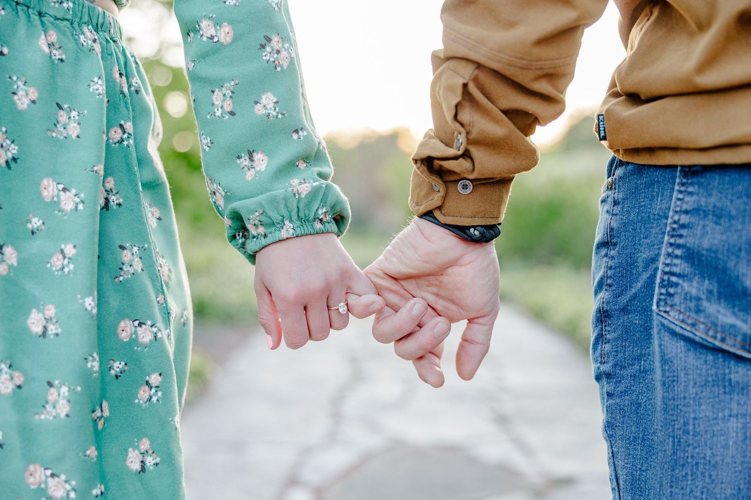 Close-up engagement photo of a couple holding hands at Cantigny Park