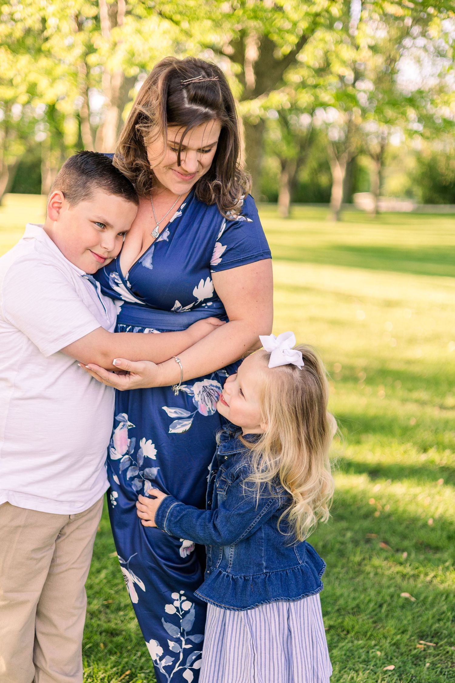 Sweet family moment captured in a park with blooming trees and golden sunlight.