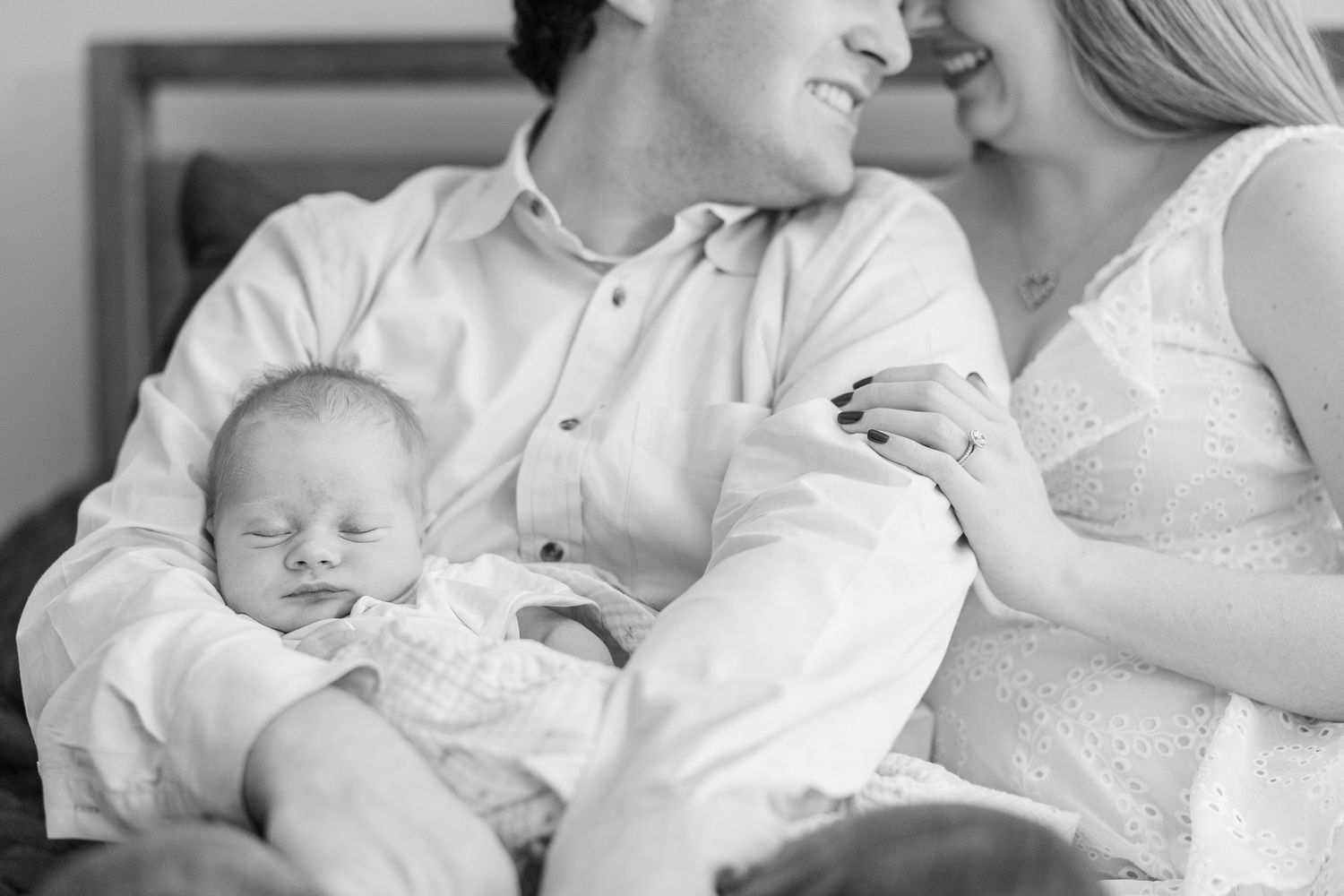 Black and white in-home lifestyle newborn photo in Vernon Hills, Illinois with sleeping baby in parents’ arms