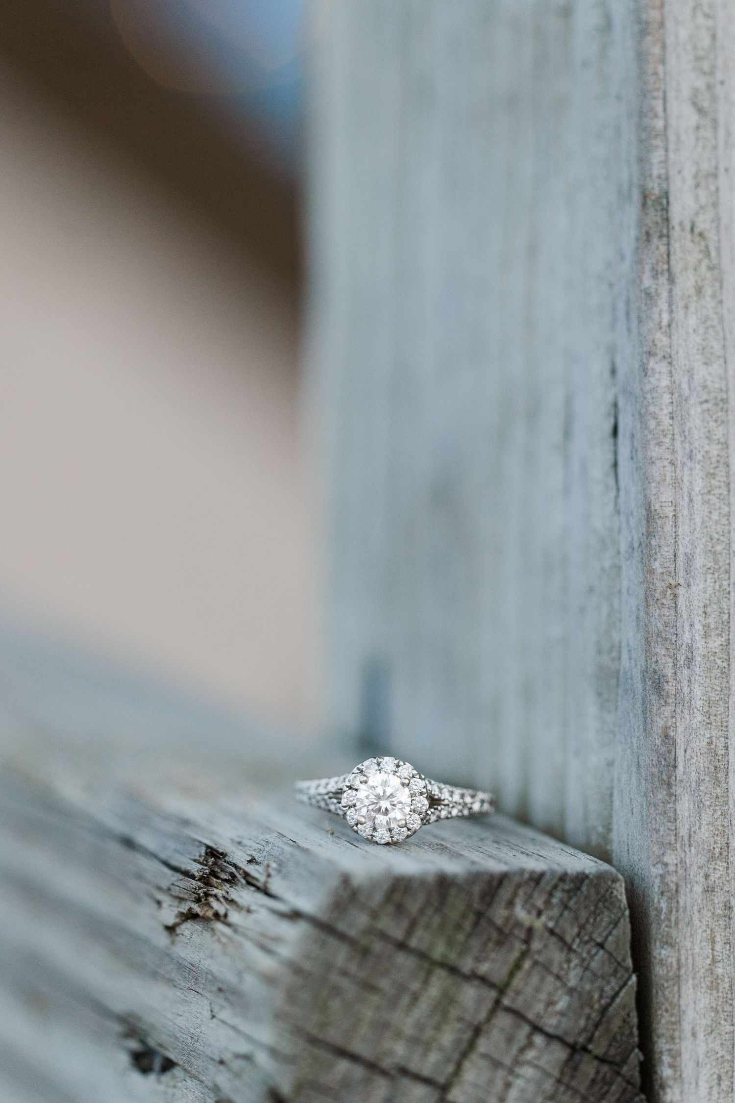 Close-up of Elizabeth's engagement ring on a wooden lifeguard stand, showing off the intricate details of the ring