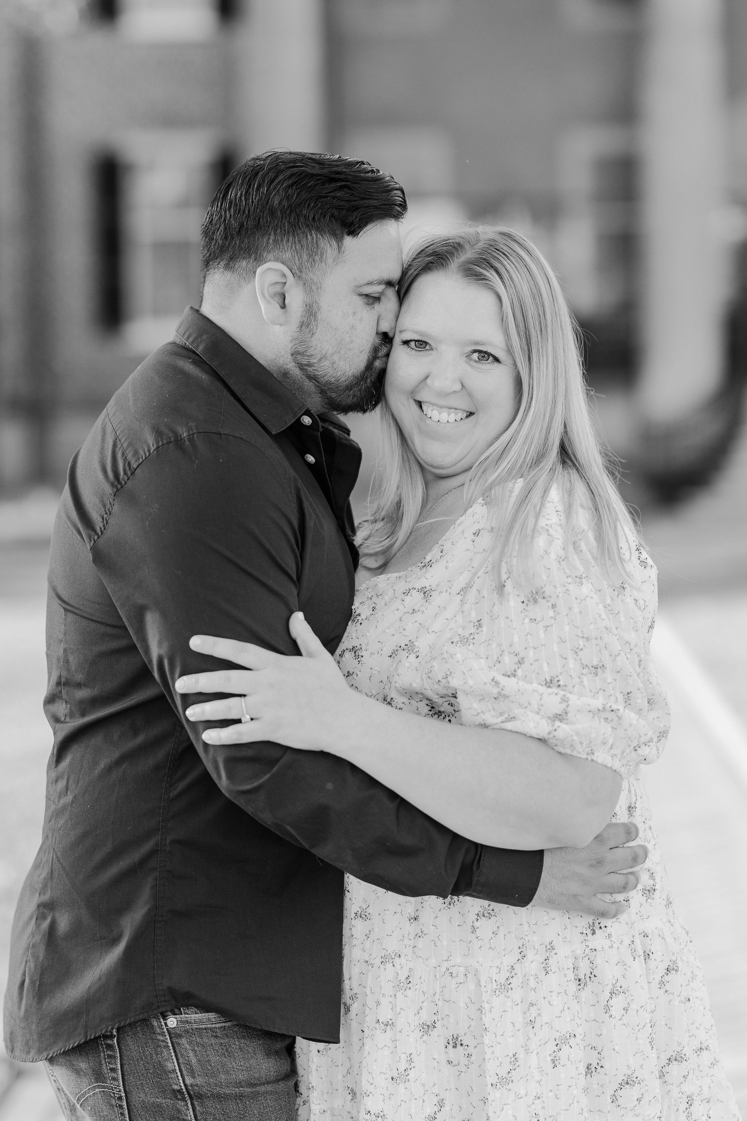 A romantic outdoor engagement portrait captured in black and white.