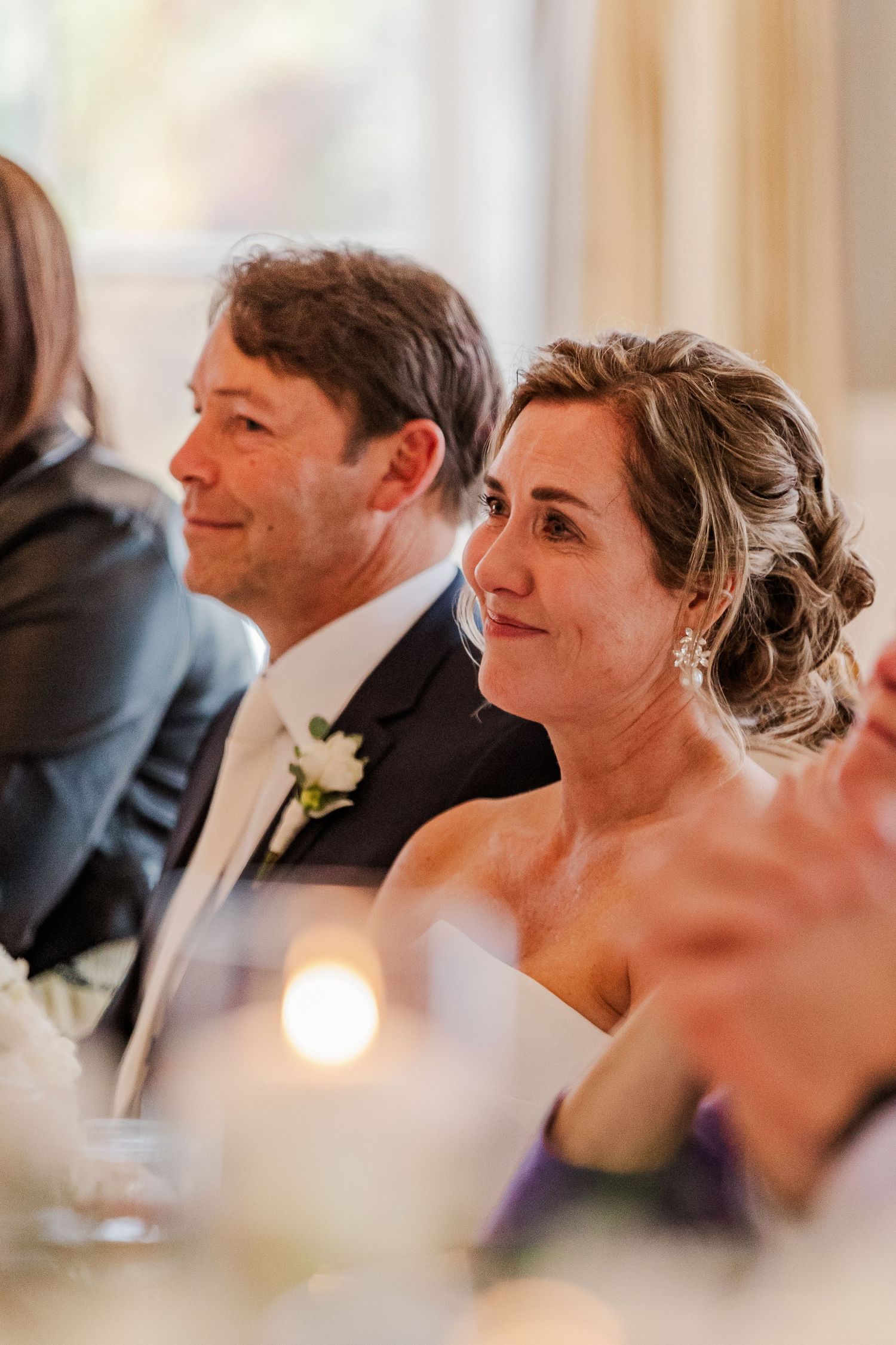 Wedding reception candid moment showing guests enjoying speeches and celebrations.