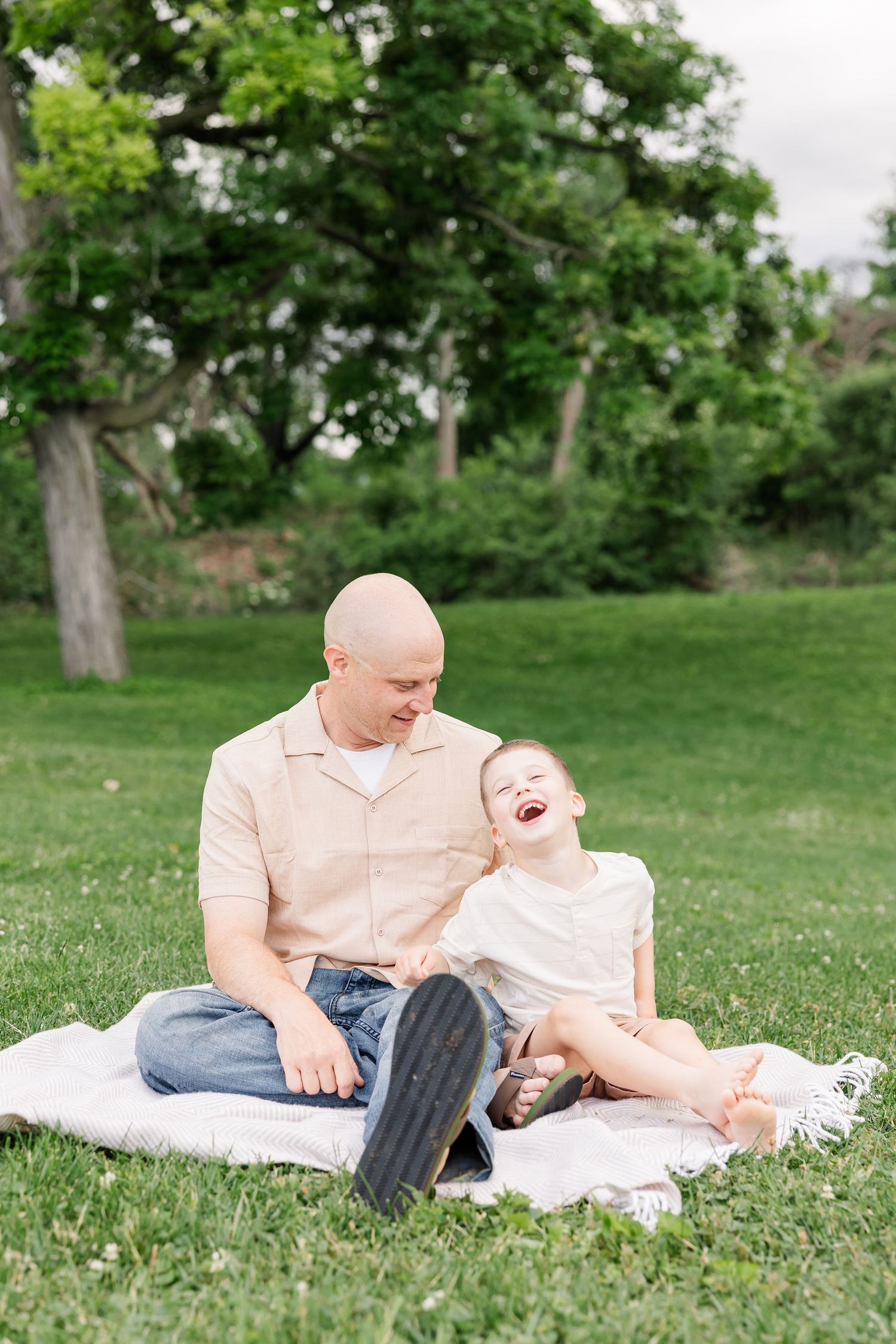 Dad snuggling his young son during a relaxed outdoor family photography session in Crystal Lake.