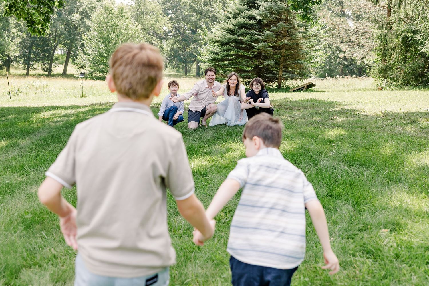Boys running together during a playful summer family reunion photo session in Crystal Lake, IL.