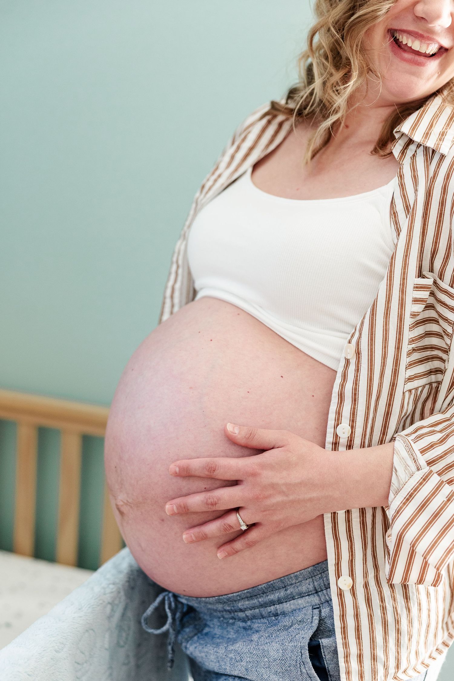 Close-up maternity portrait of baby bump during a cozy in-home maternity session in Crystal Lake.