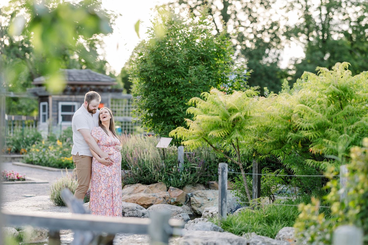 Wide garden maternity portrait at Cantigny Park with expecting couple surrounded by summer greenery