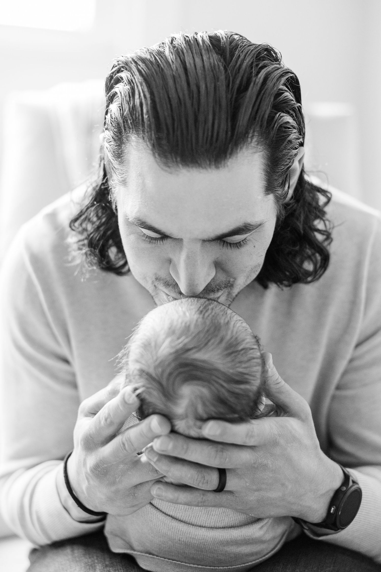 Father kissing his newborn baby during an in-home lifestyle newborn photography session in Palatine IL