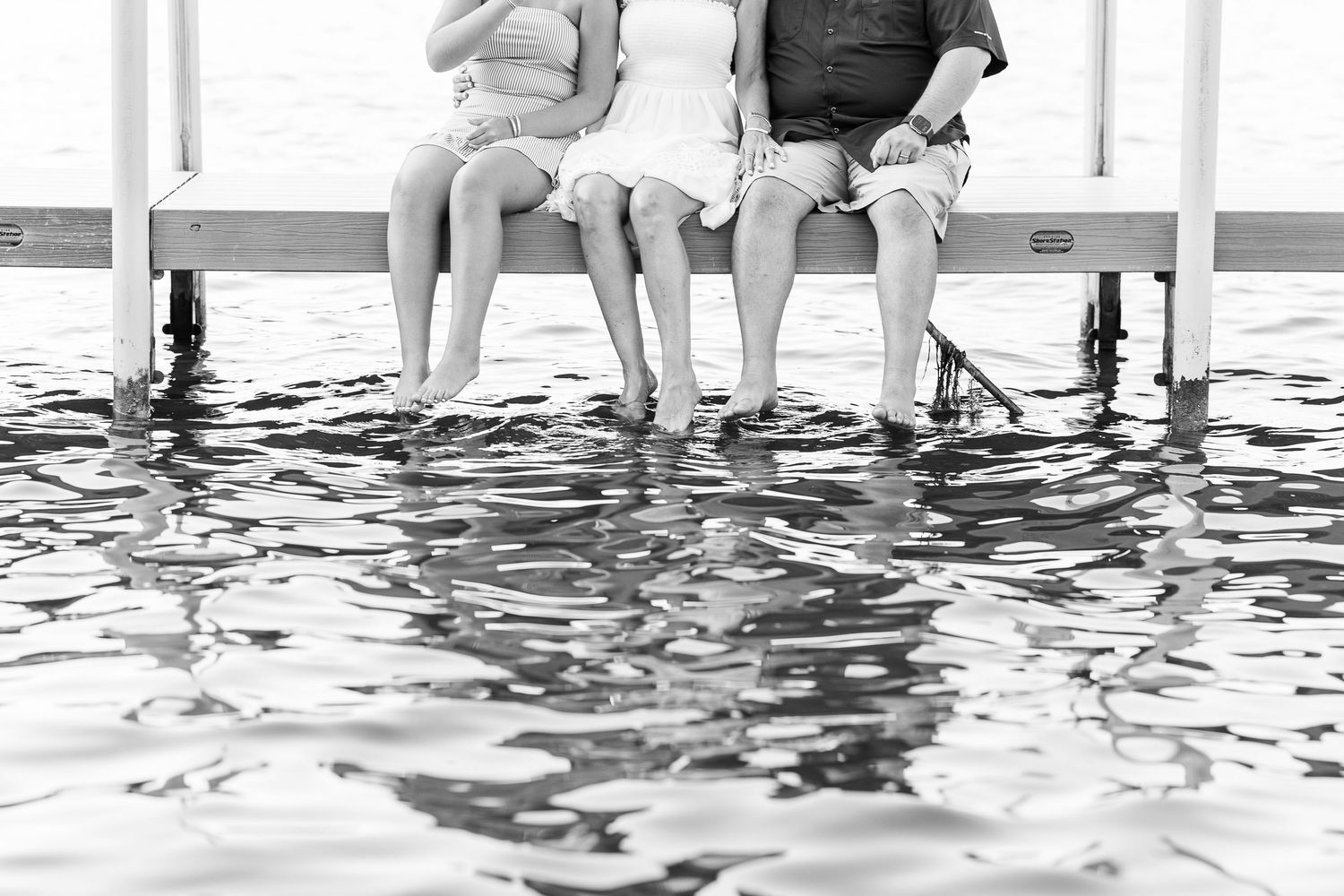 Black and white family portrait sitting on dock during Pistakee Lake family photos