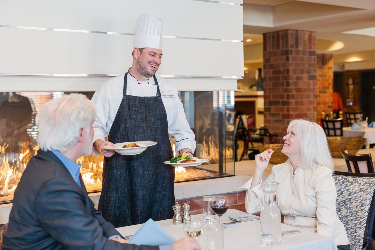 Beacon Hill senior living branding photo in Lombard, Illinois featuring chef presenting meal to residents