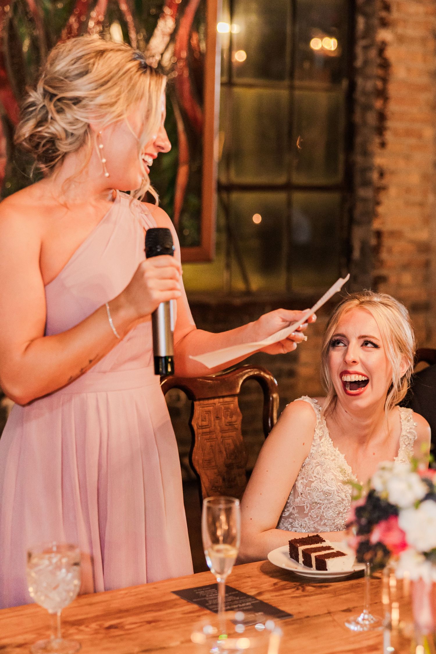 Toast moment at wedding reception with champagne and dessert at rustic venue.
