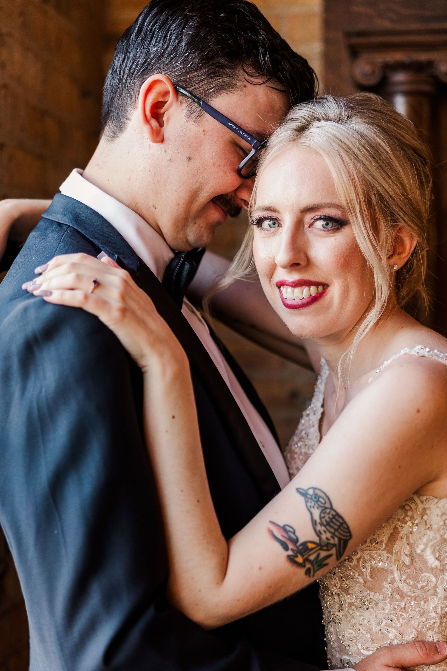 A romantic wedding moment shows a couple embracing in formal attire against a rustic backdrop.