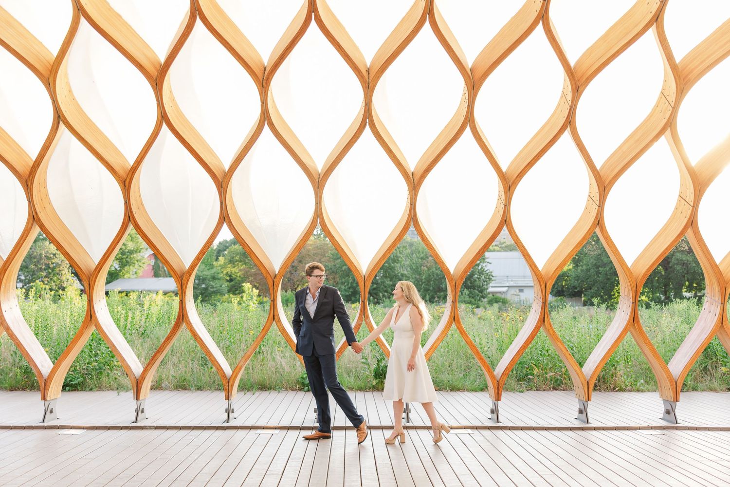 Elizabeth and Joe standing under the Honeycomb Pavilion in Lincoln Park, Chicago, smiling at each other