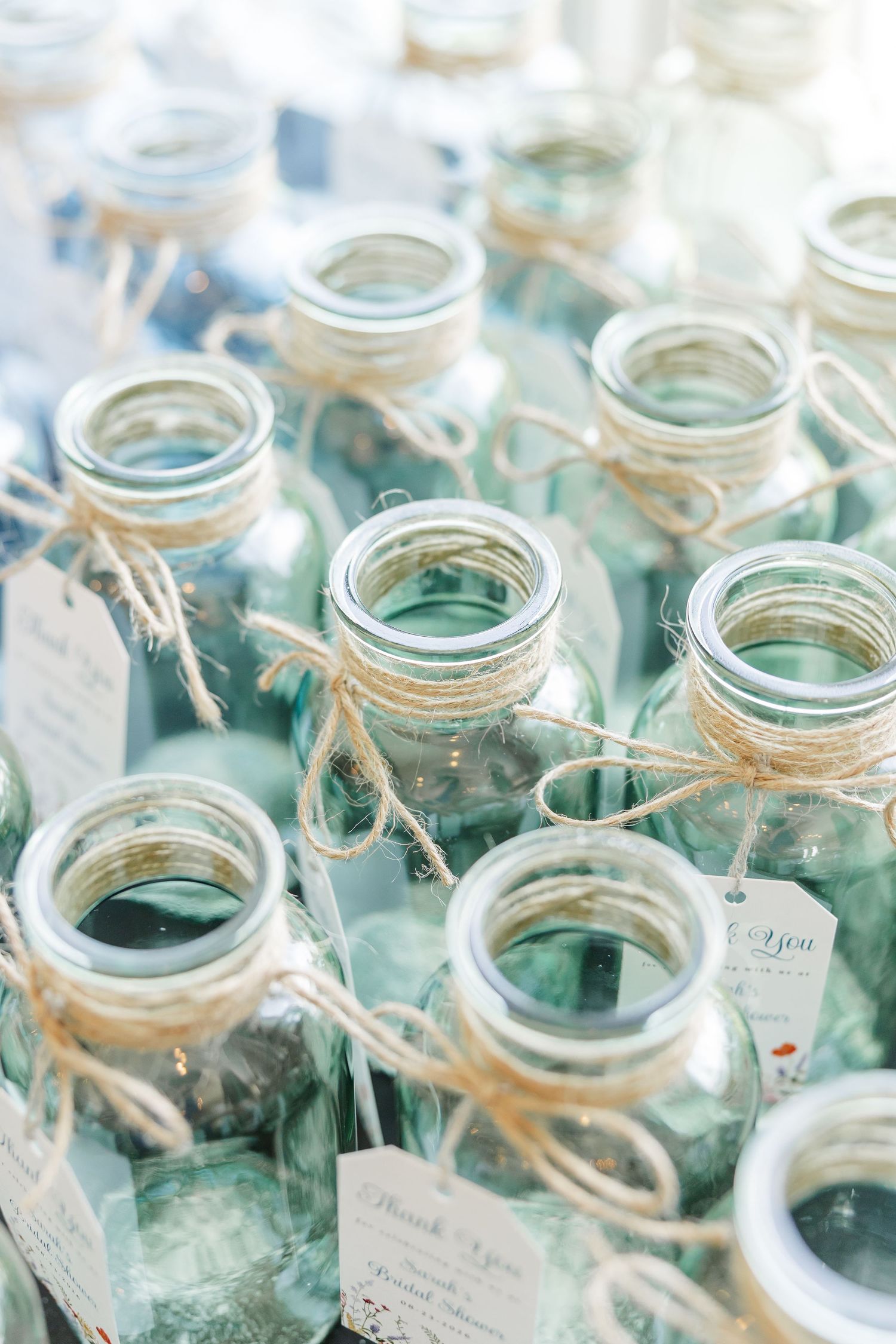 Mason jar party favors with twine and tags at wildflower bridal shower