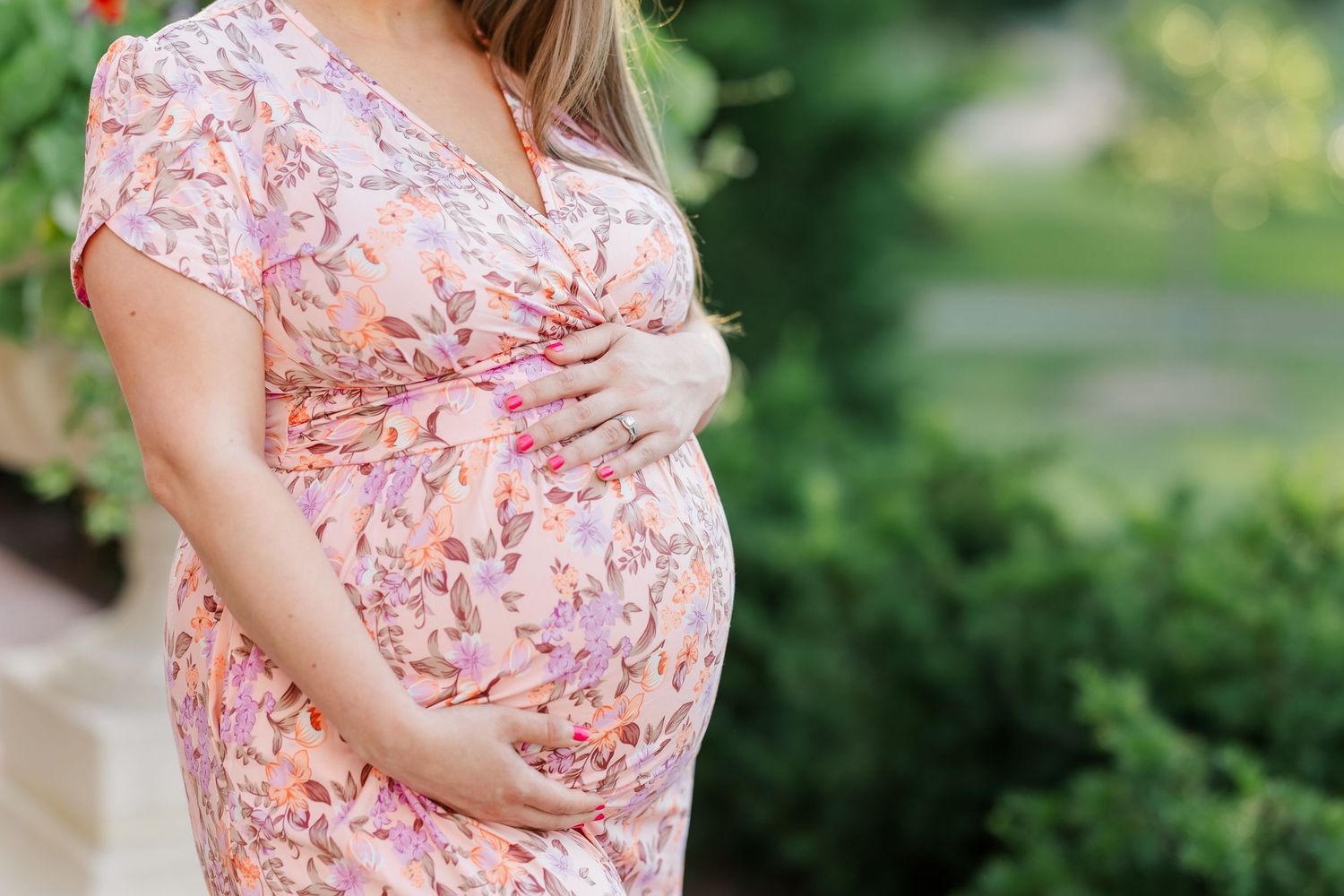 Close-up baby bump maternity photo in a floral dress during a Cantigny Park maternity session