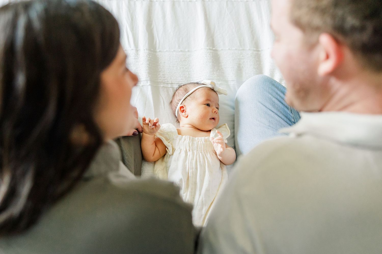 Parents smiling at newborn baby girl during a cozy lifestyle newborn session at home