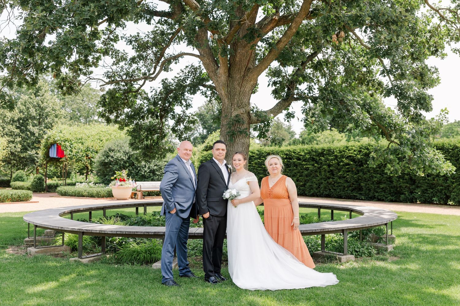 Newlyweds posing with family members beside a garden fountain at Cantigny Park in Wheaton, Illinois.