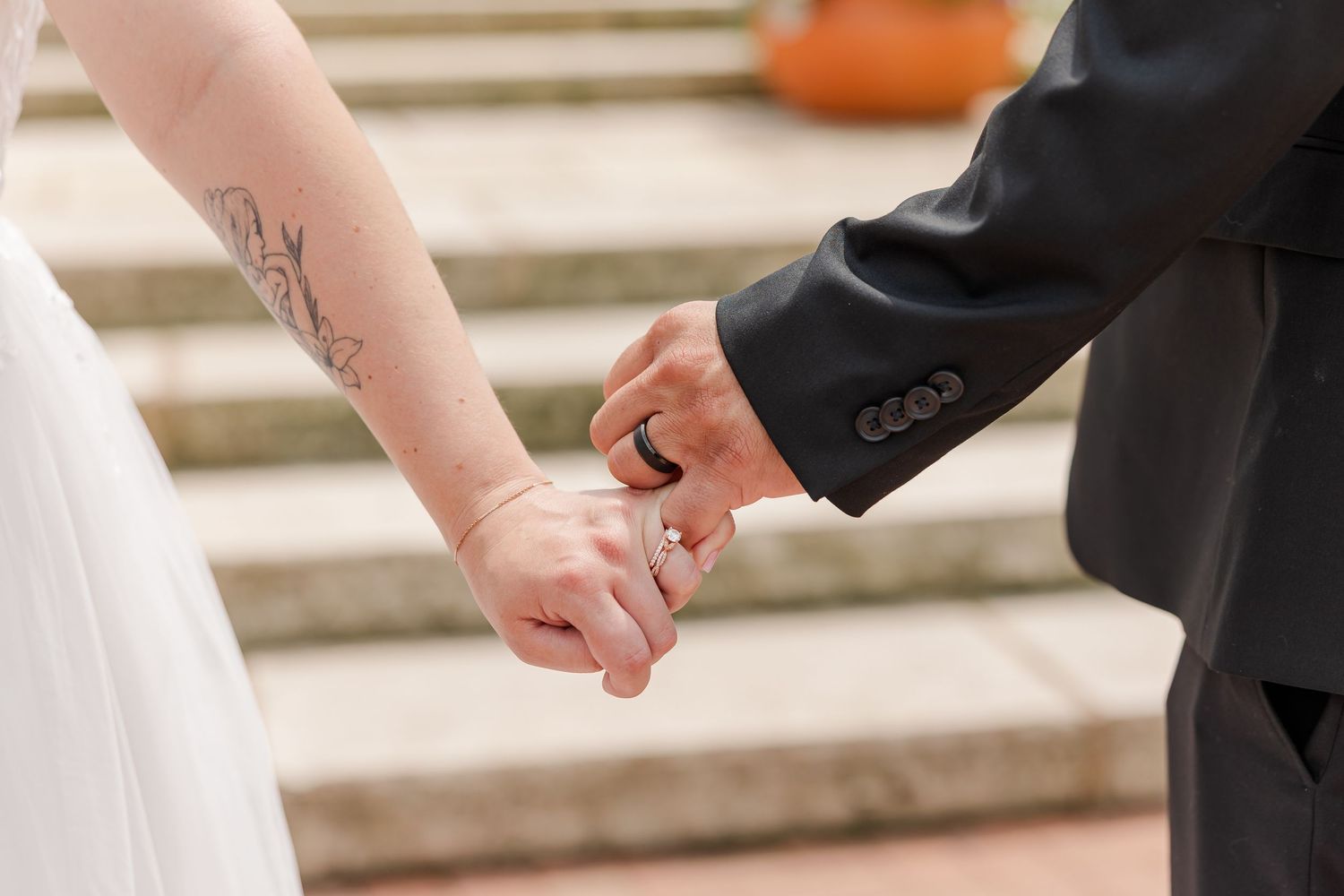 Close-up of Monika and Rafael holding hands on the steps during their Cantigny Park wedding portraits.