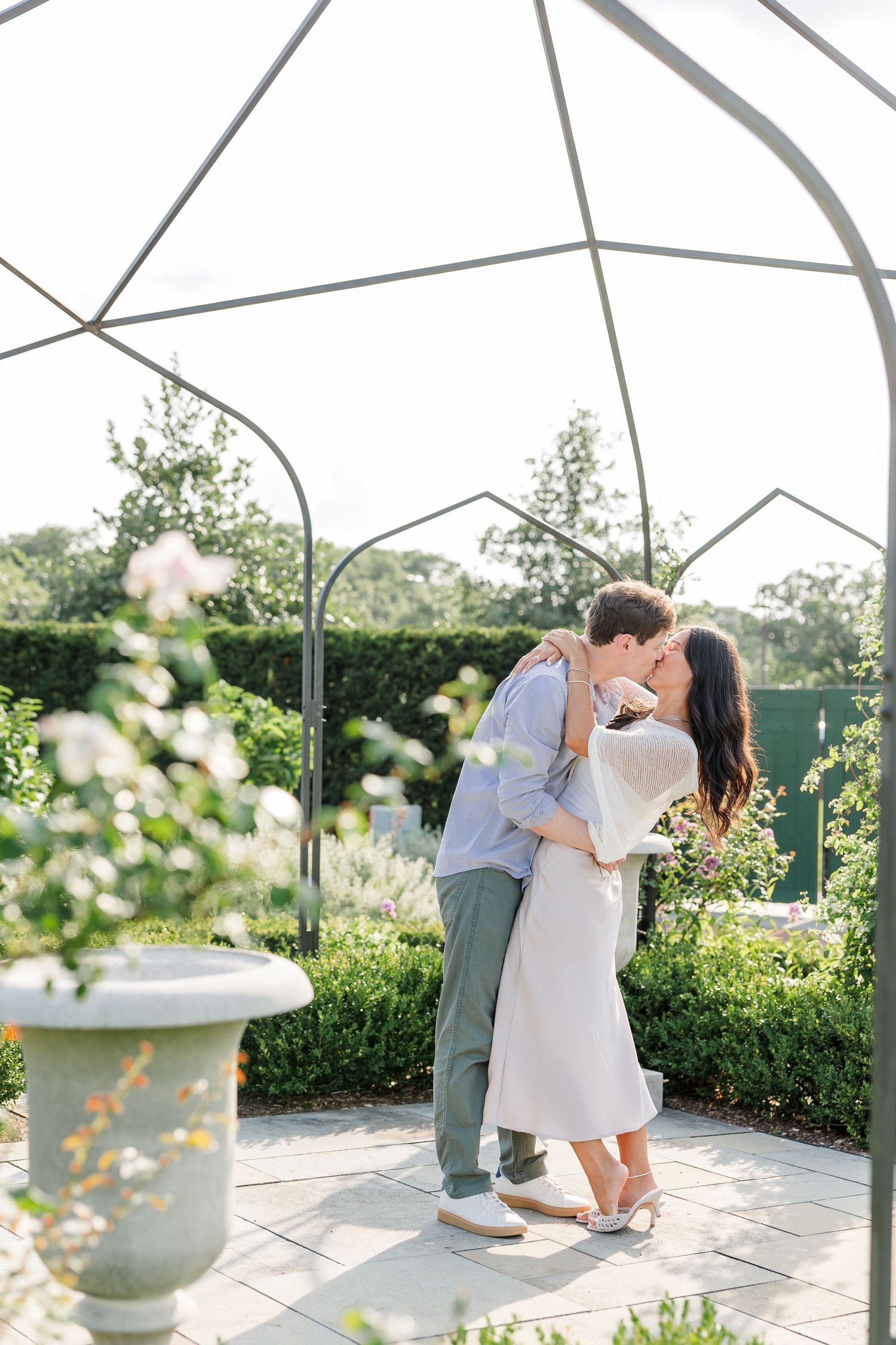 Newly engaged Alysia and Jack kiss in the colorful rose garden at Cantigny Park.