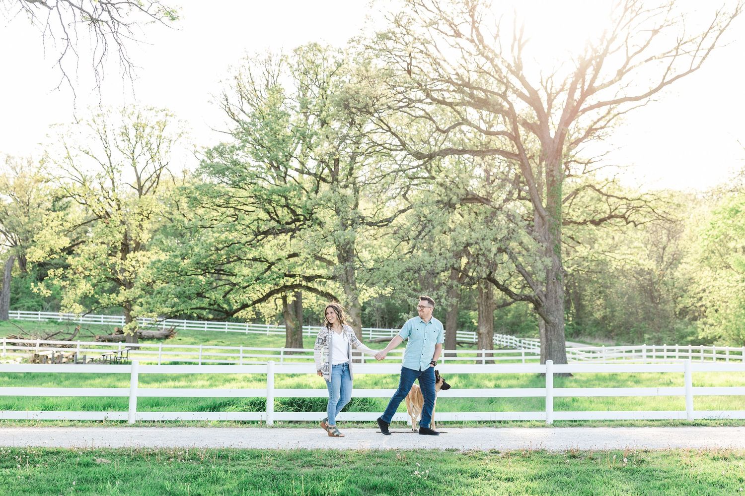 Engagement photos near the white fence at St. James Farm Preserve in Warrenville