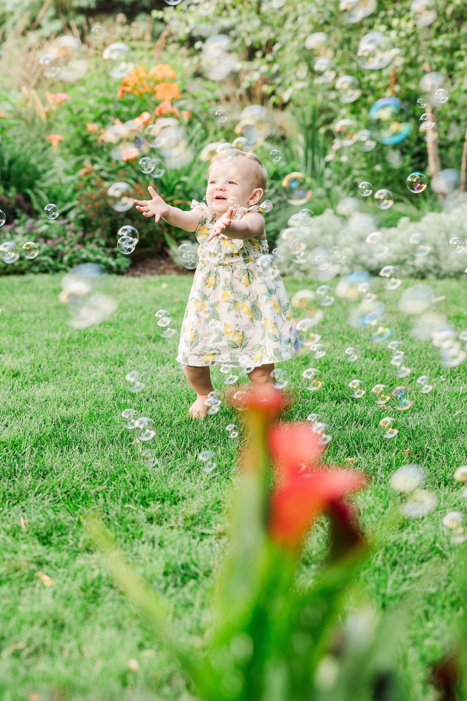 A joyful scene in a garden with floating bubbles and flowers on a sunny day.