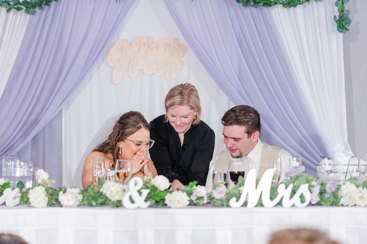 Cassie Lacina sharing a same day slideshow to a bride and groom at their sweetheart table