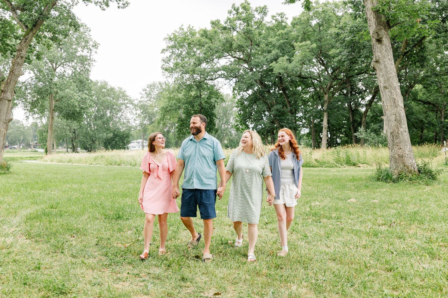 Adult siblings walking together during a relaxed family reunion photo session in Crystal Lake, Illinois.