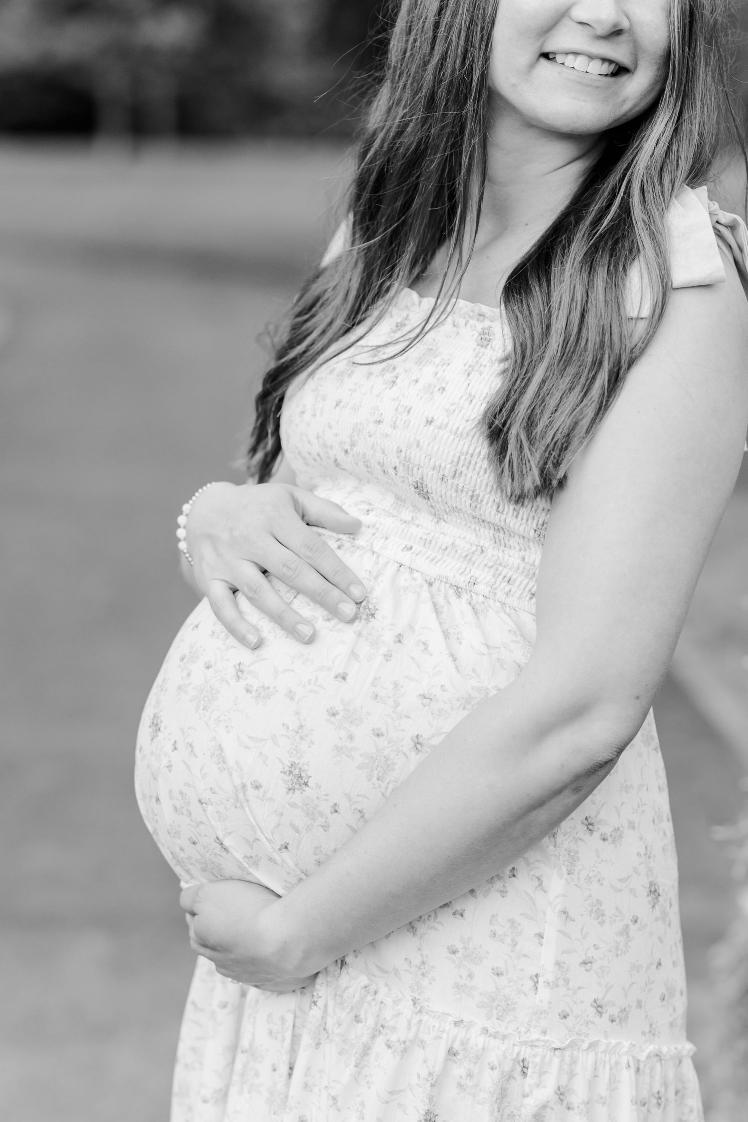 Black and white maternity portrait of an expecting mother holding her baby bump