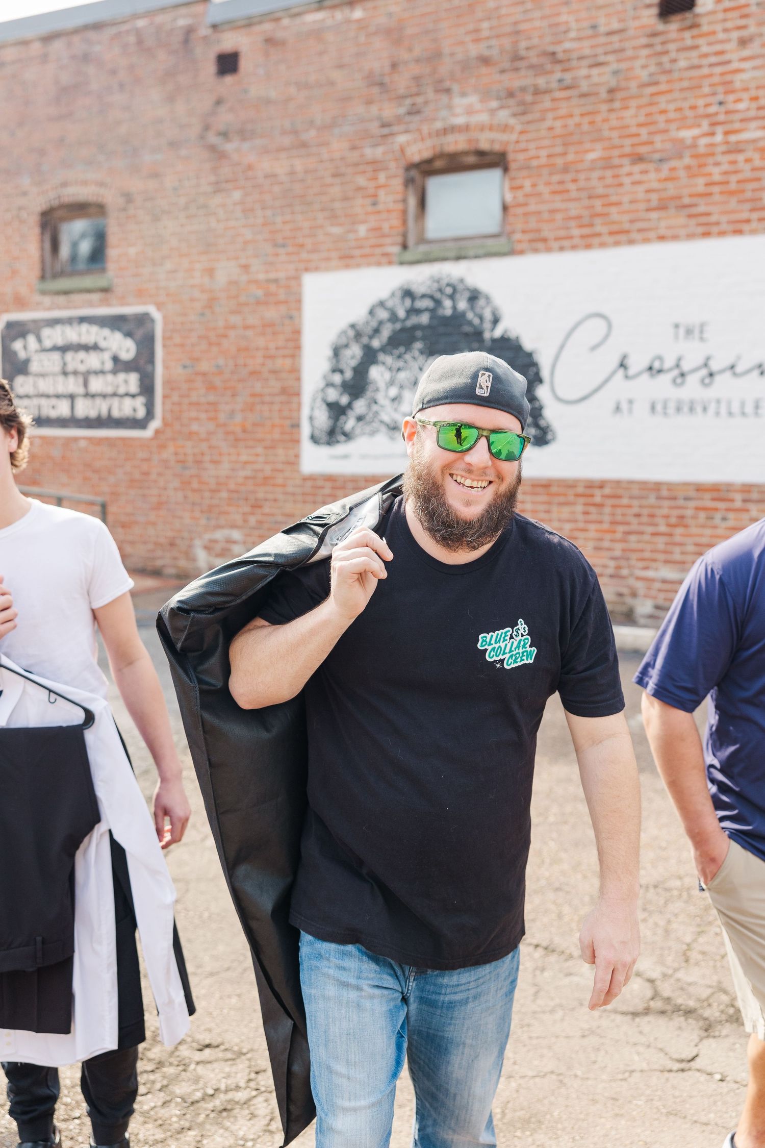 People walking past a vintage brick building with signage for The Crossing.
