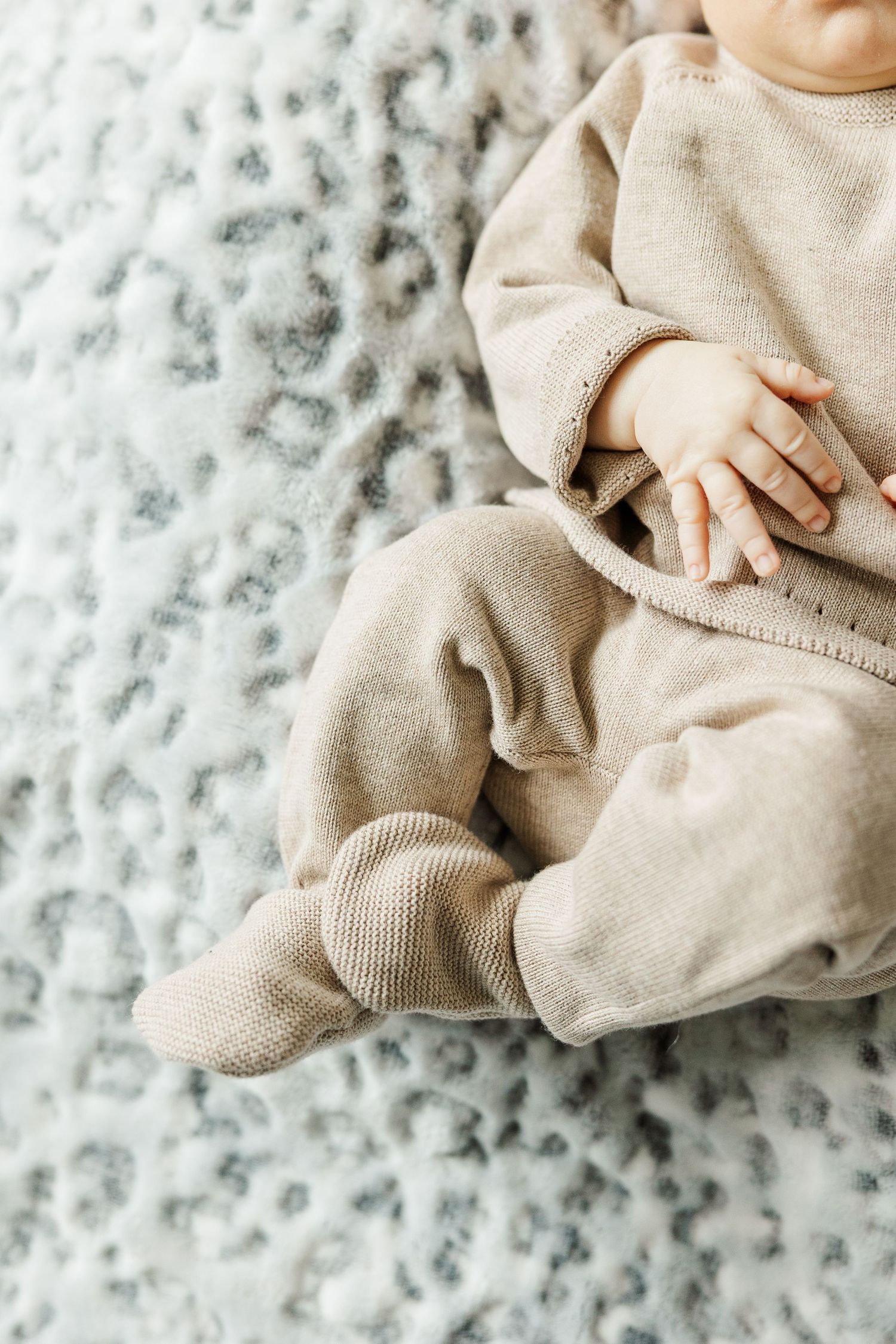 Newborn baby wearing a neutral knit outfit photographed during an in-home lifestyle newborn session in Palatine IL