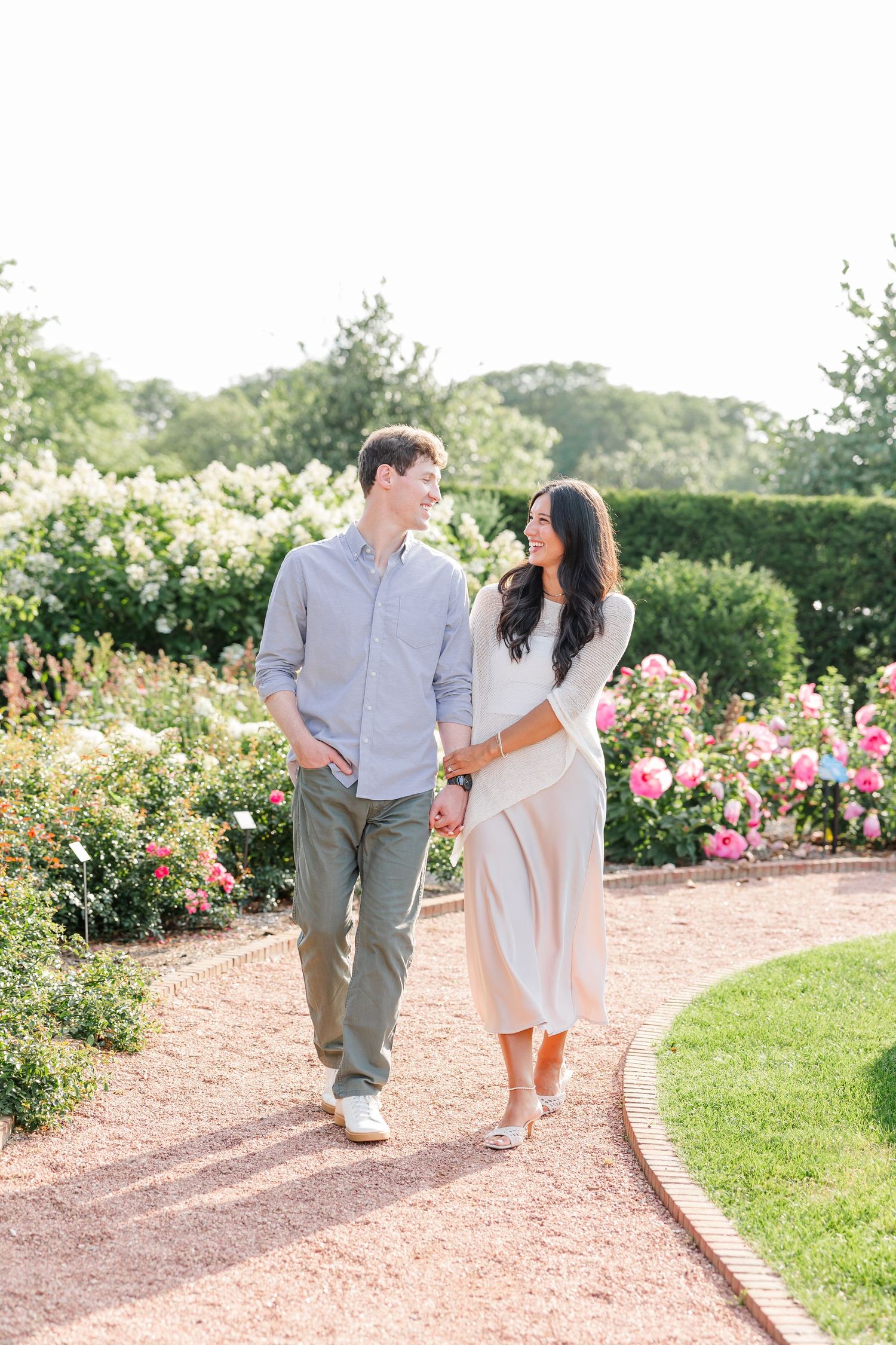 Alysia and Jack walk hand in hand past colorful flowers at Cantigny Park.