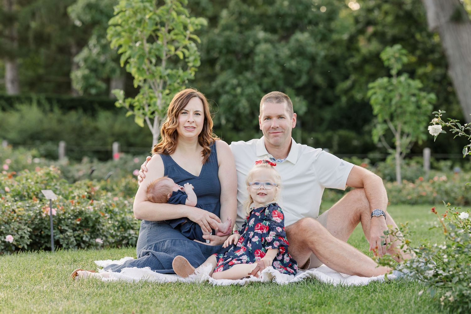 Lawler family sitting on a blanket for outdoor newborn family portraits at Cantigny Park.