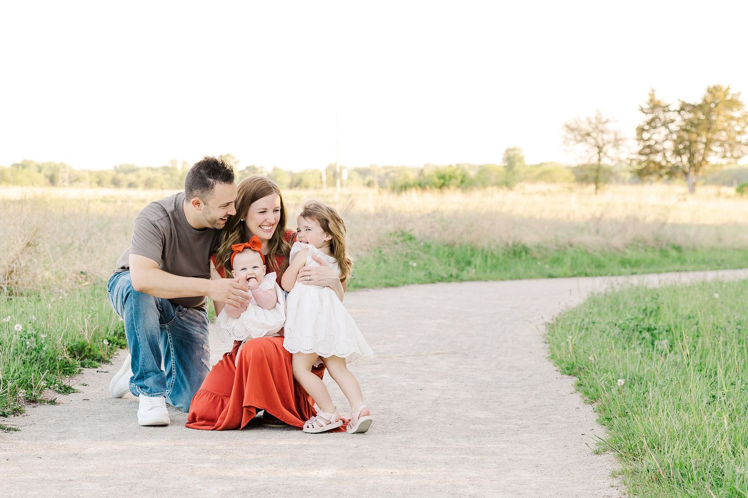 Family sharing a tender moment together on a walking path during golden hour.