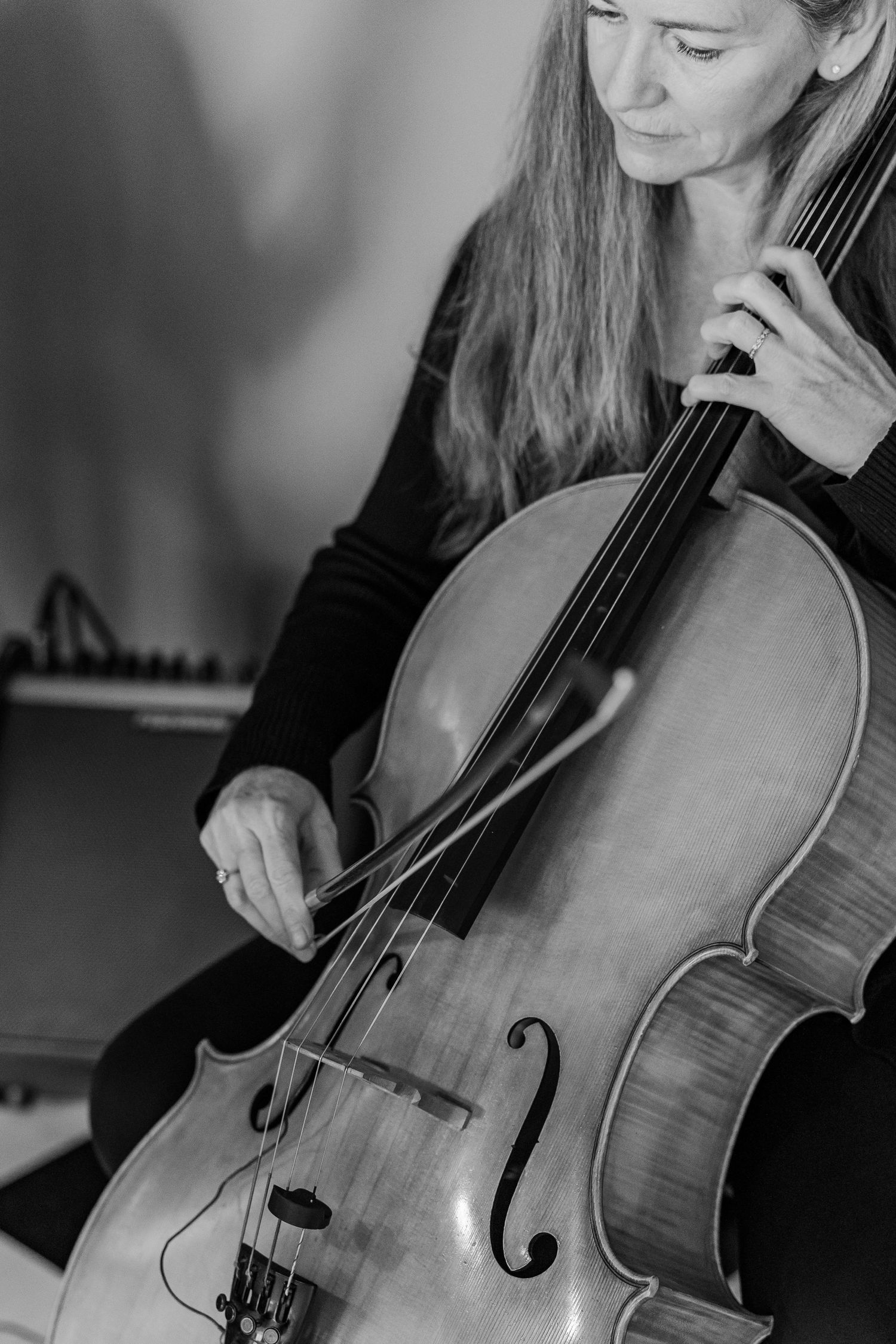 Black and white portrait of a cellist performing with focused concentration.