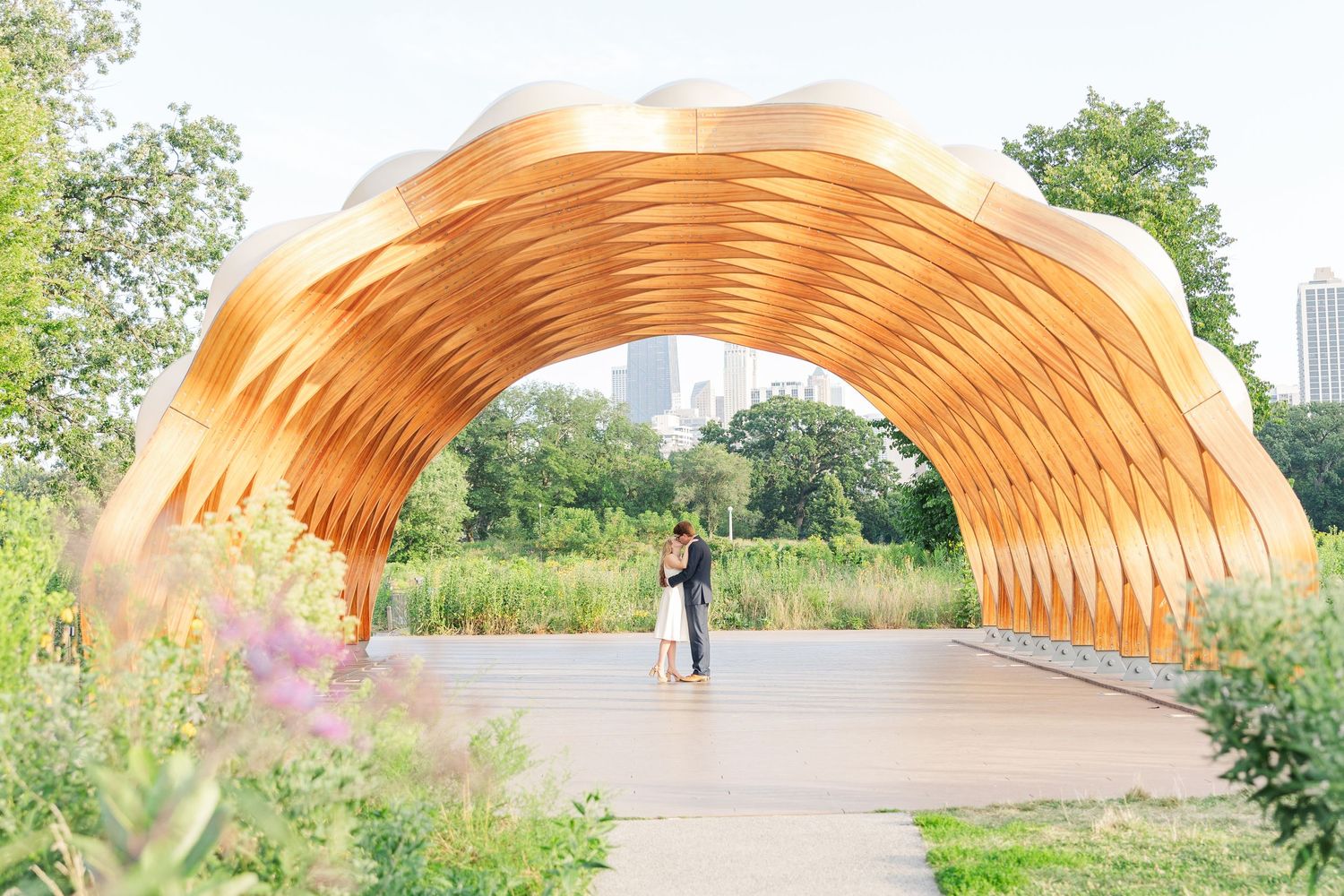 Elizabeth and Joe standing under the Honeycomb Pavilion in Lincoln Park, Chicago, kissing each other