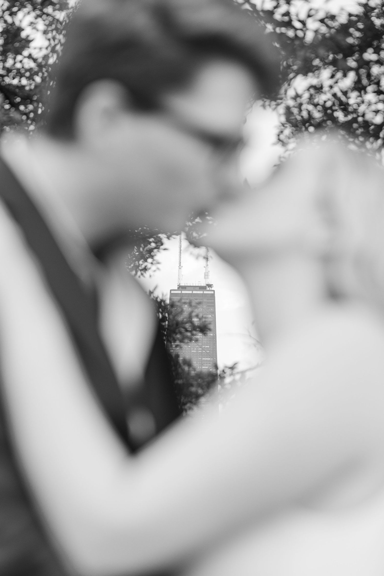Elizabeth and Joe kissing with the Chicago skyline in the background at North Avenue Beach during sunset