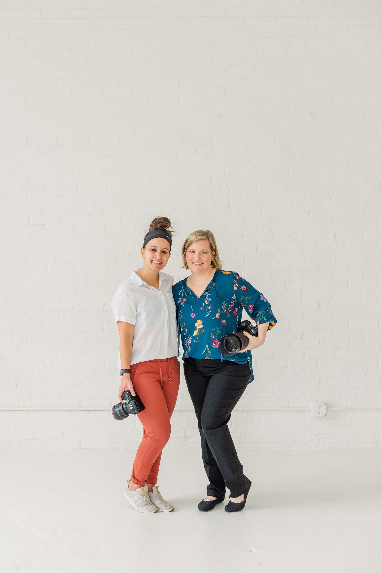 Cassie Lacina and Rachael Watson posing together in a bright white studio