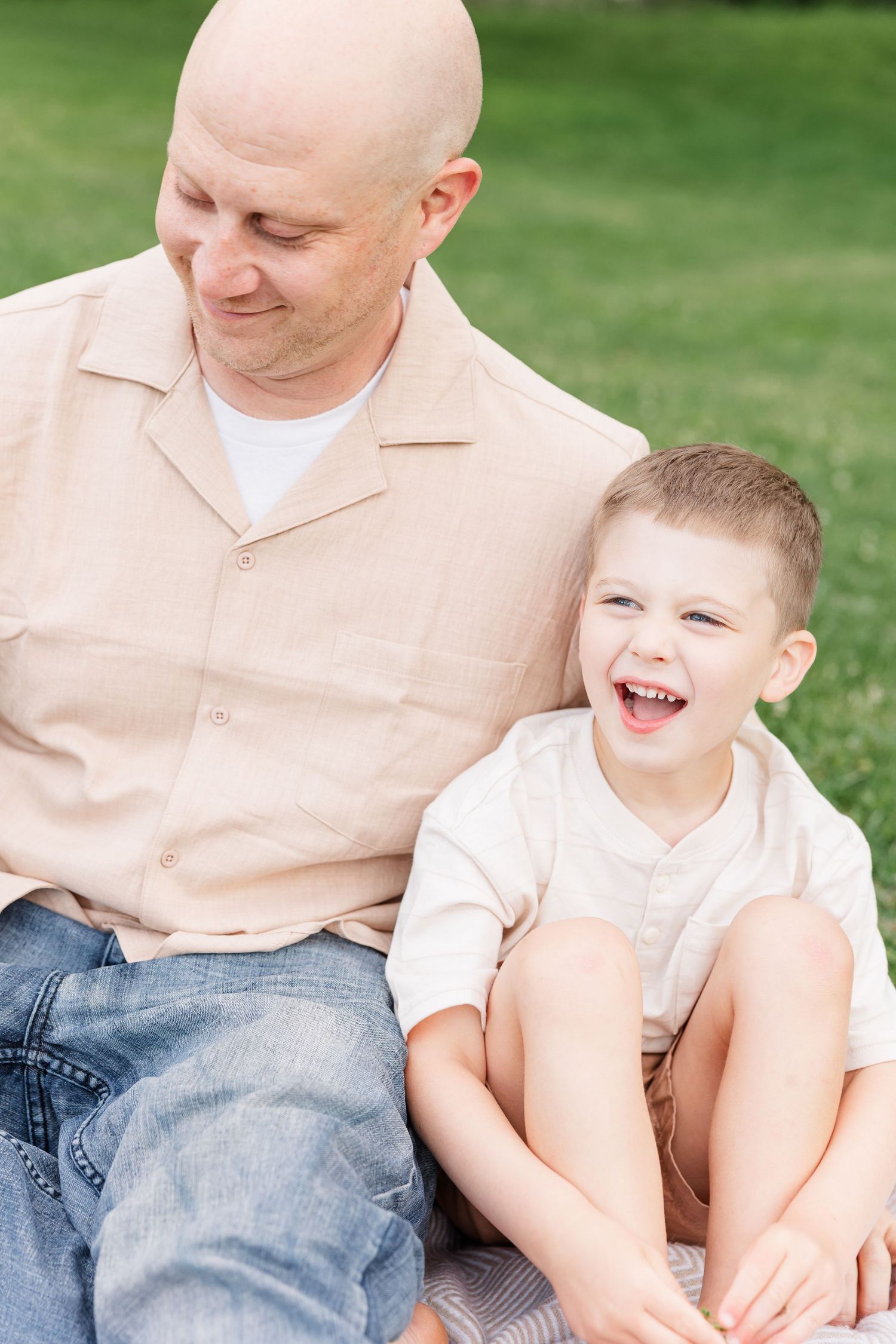 Dad smiling with his son during a sweet family portrait session at Shamrock Hills Park in Crystal Lake.