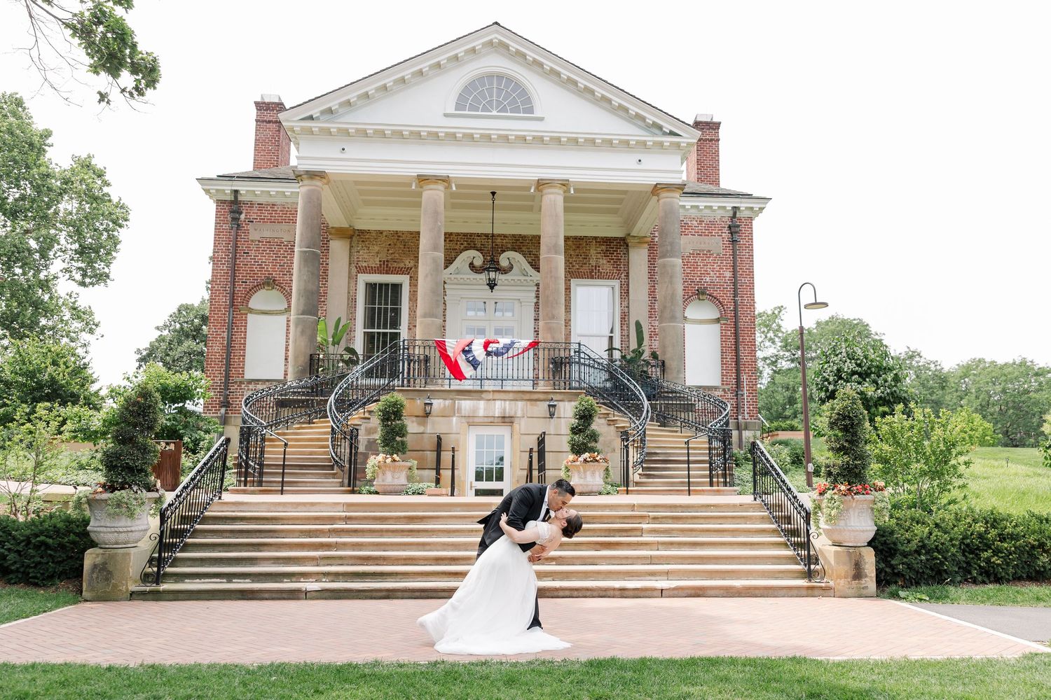 Rafael dipping Monika in front of McCormick House during their Cantigny Park wedding portrait session.