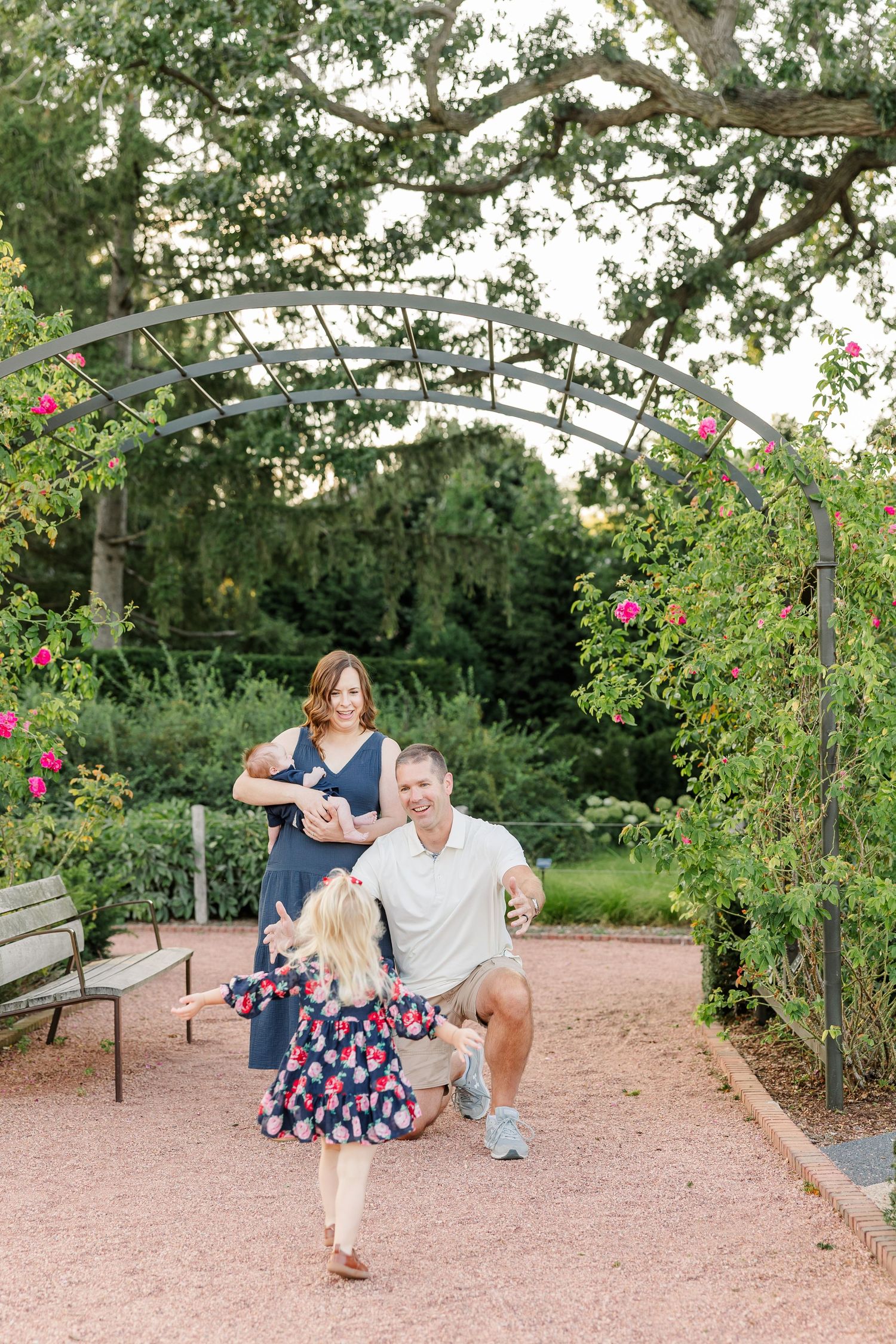 Caroline running toward the camera while her parents smile with baby Lincoln behind her.
