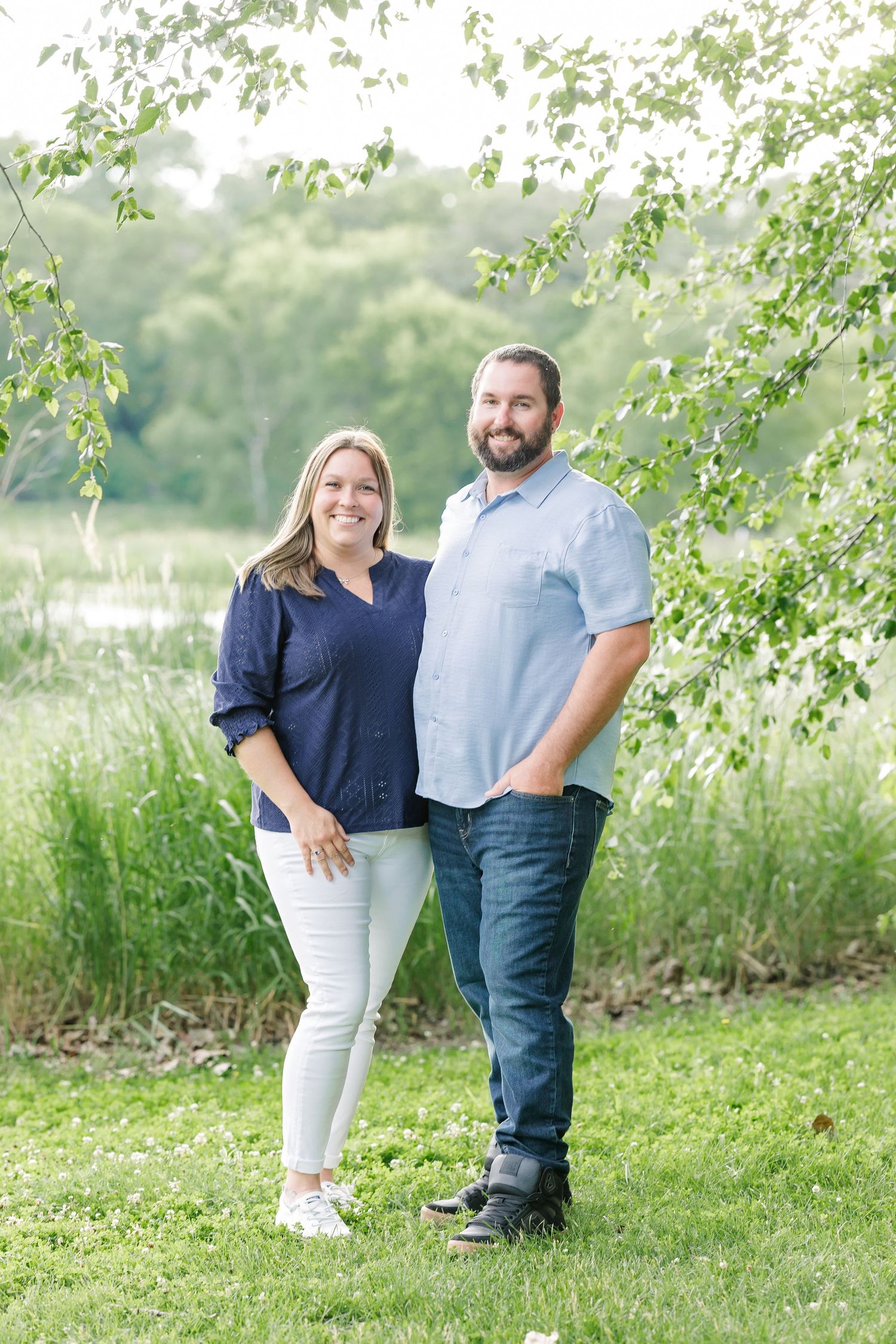 Couple smiling together in summer greenery during an outdoor family session at Veterans Acres Nature Center in Crystal Lake
