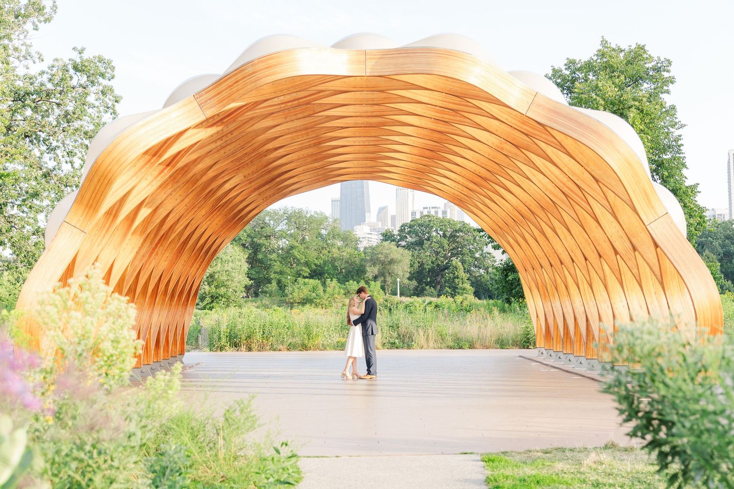 Elizabeth and Joe standing under the Honeycomb Pavilion in Lincoln Park, Chicago, kissing each other