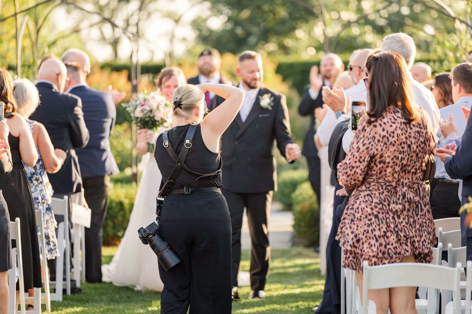 Cassie Lacina photographing a wedding ceremony from the center aisle