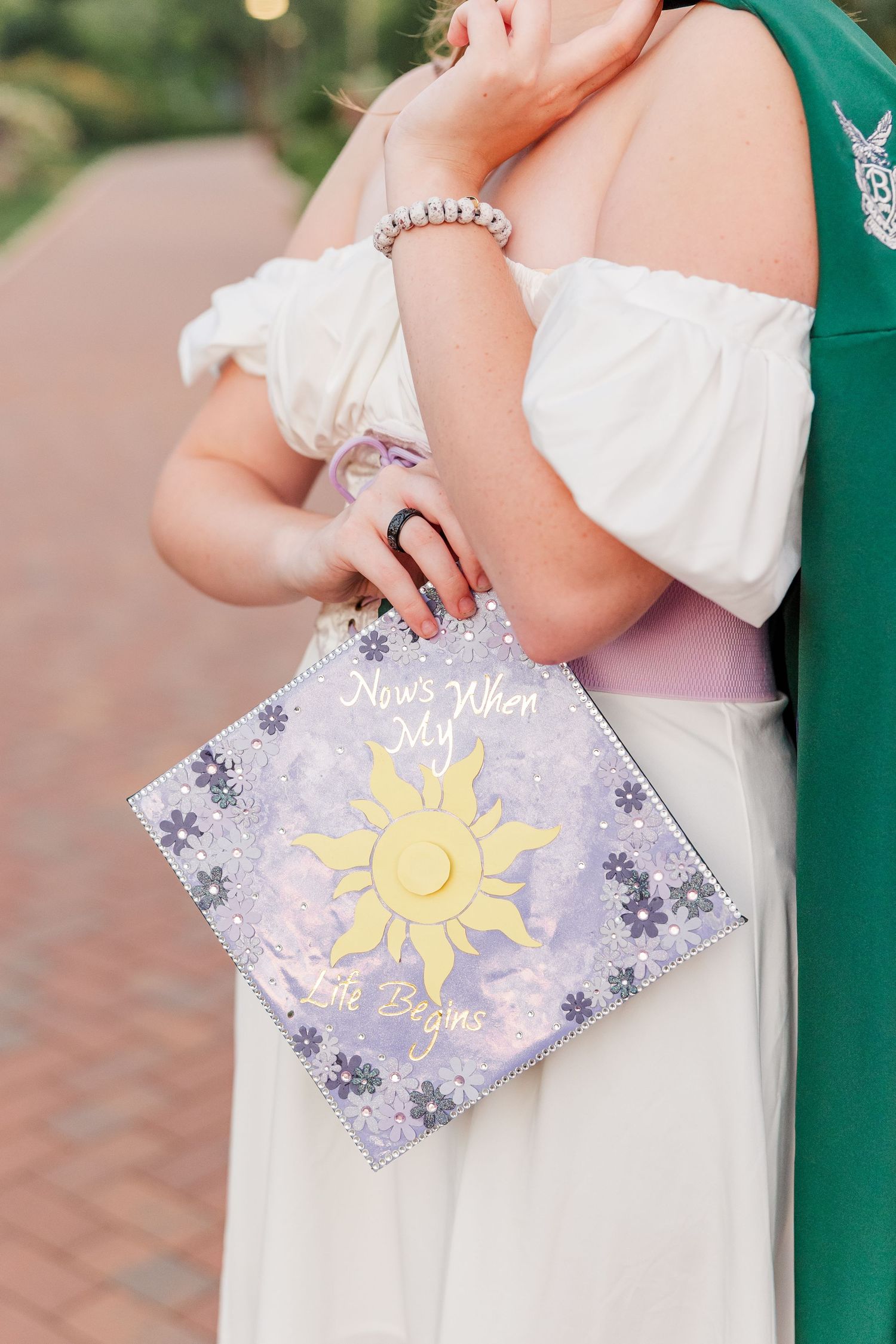 Samantha holds her Tangled-inspired graduation cap during her creative Bartlett High School senior portraits.