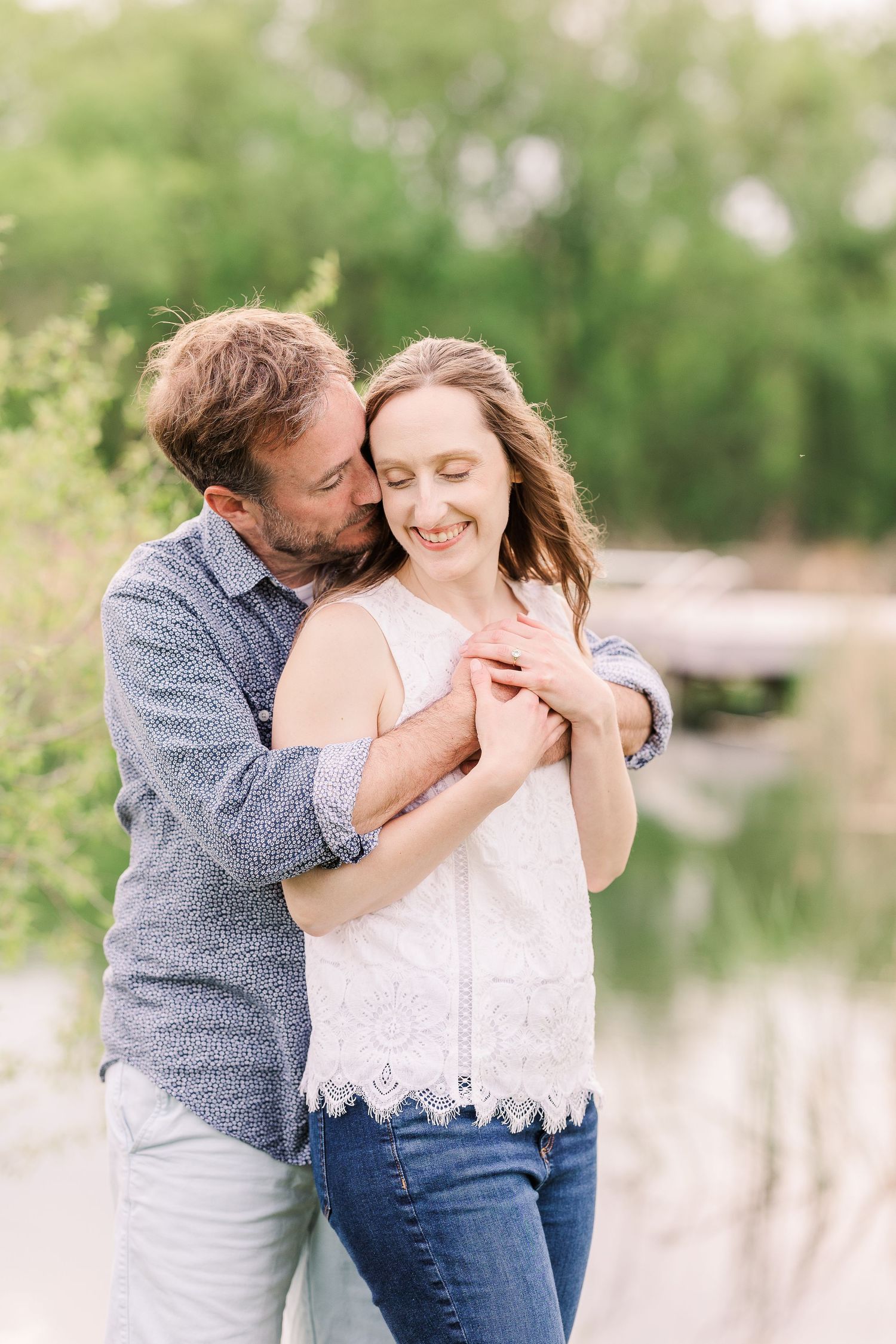 A tender moment between a couple by a lakeside in spring.