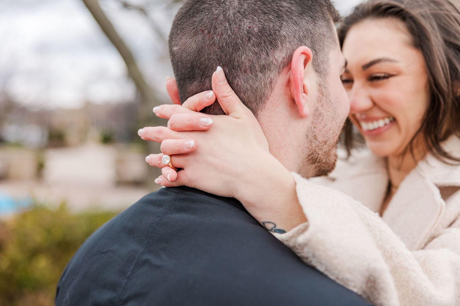 An intimate moment shared with hands displaying an engagement ring against a winter backdrop.