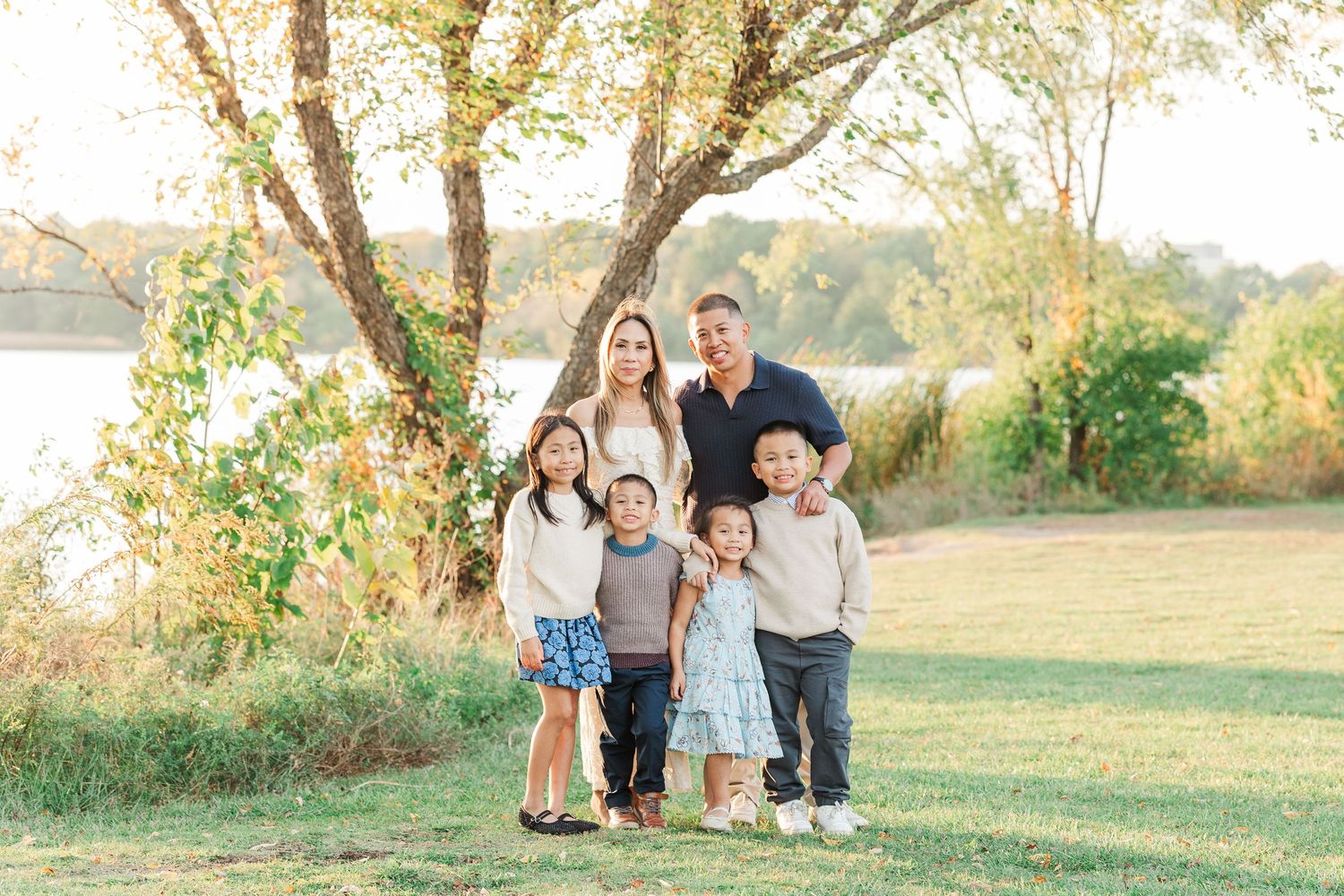 A group of people walking together through a grassy field at sunset during a fall photo session. Busse Woods