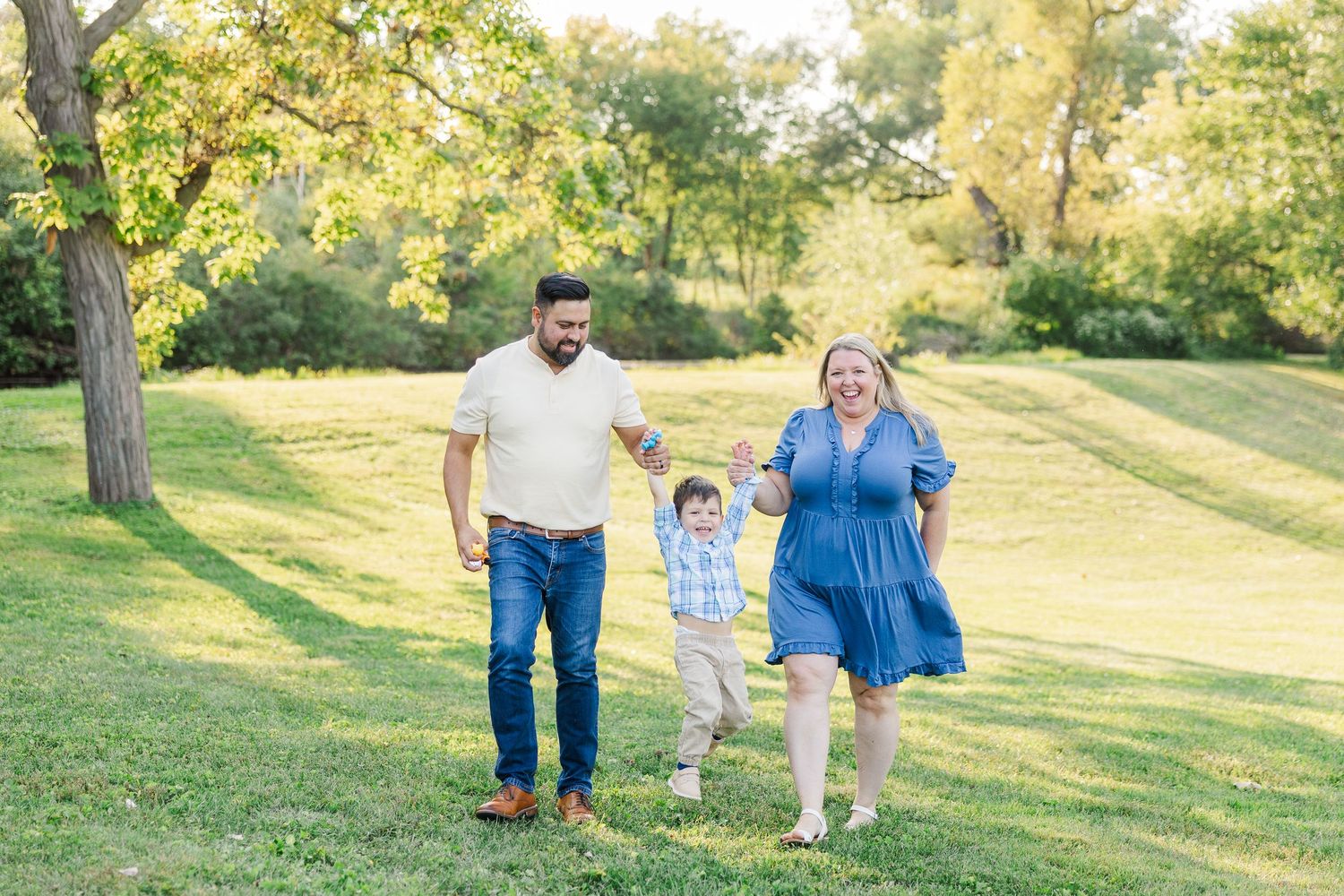 A tender family moment captured in a series of photos on grassy hillside during golden hour at sunset.Sorg family portraits at Shamrock Hill