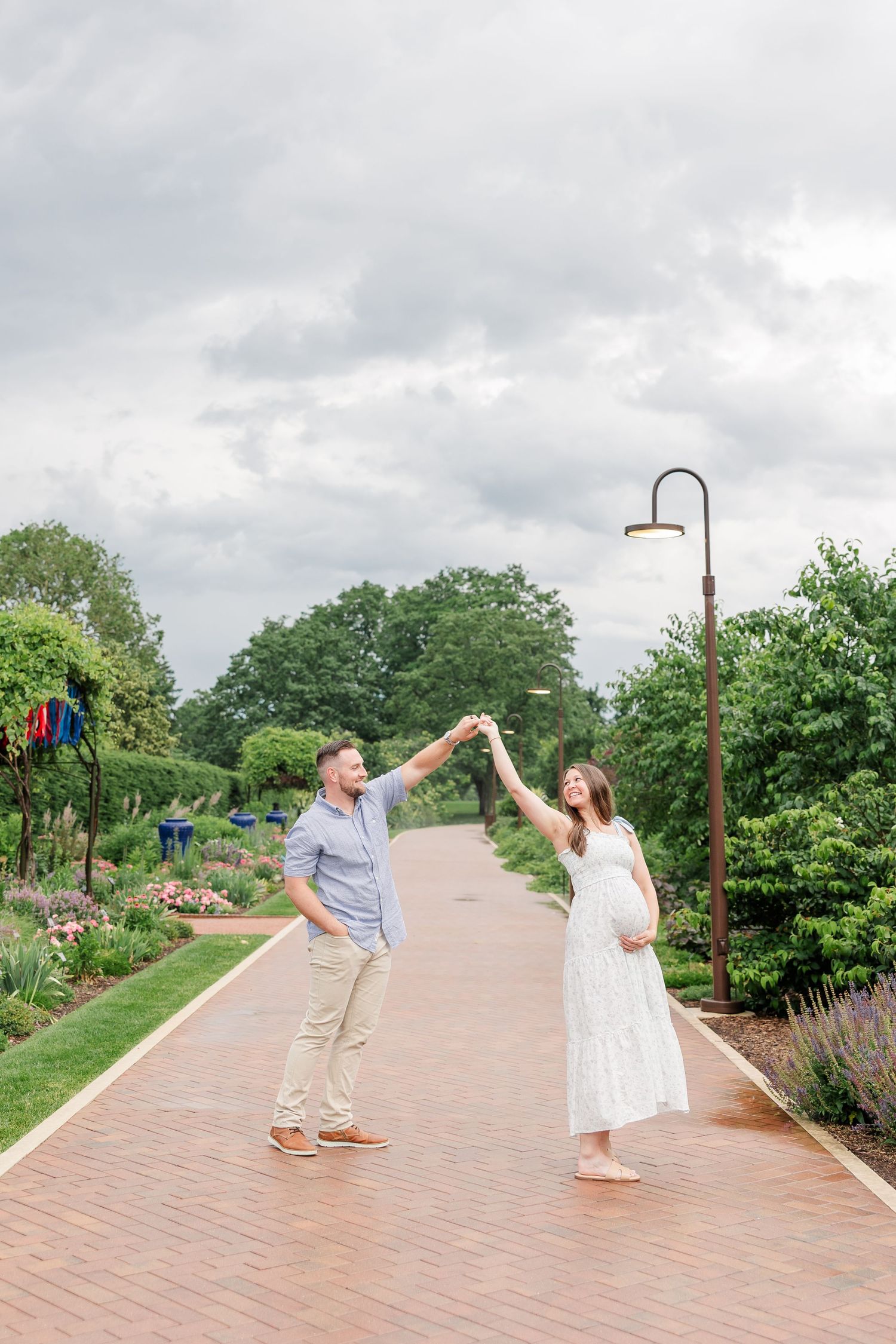 Expecting parents holding hands on a quiet pathway during their maternity session