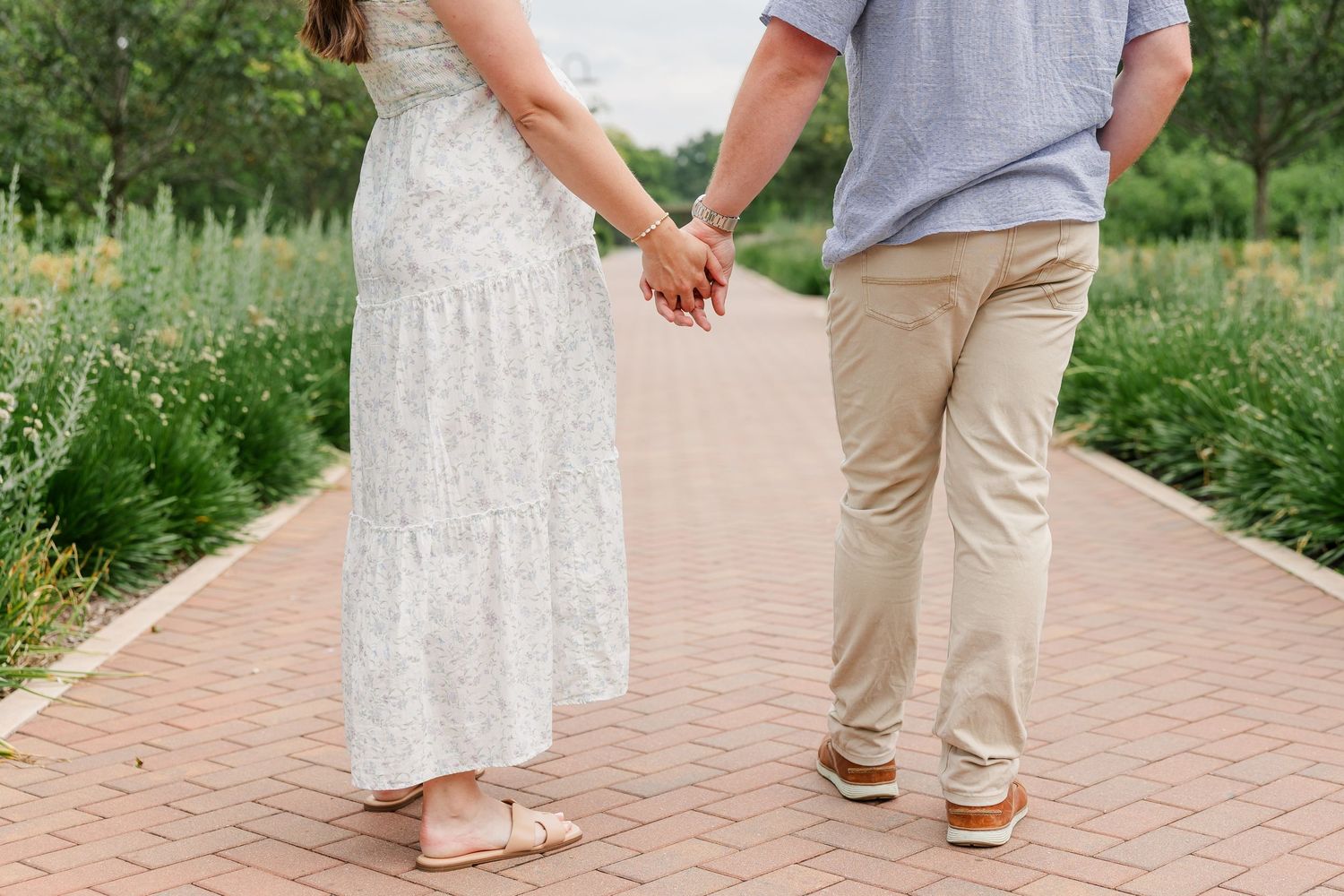 Expecting parents walking hand in hand during their Cantigny Park maternity photos