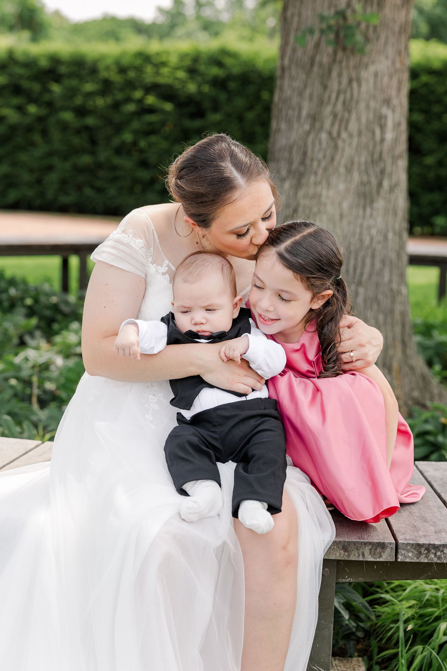 Bride cuddling her baby and young daughter during family wedding portraits at Cantigny Park.